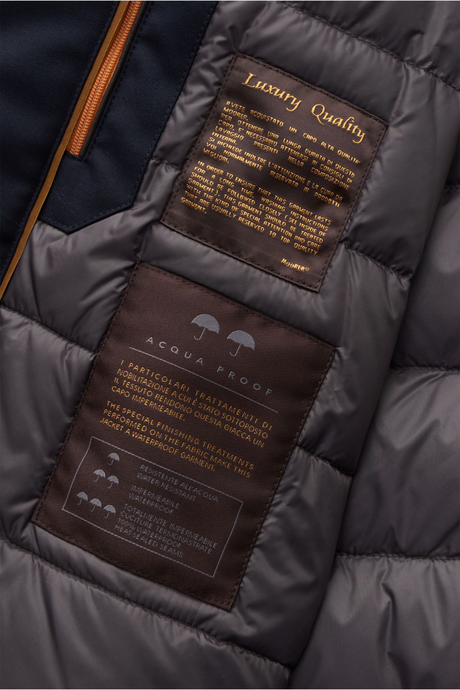 Close-up inside view of the Moorer Down jacket 'Albini' navy showing quilted lining and luxury quality labels.

The short cut, luxurious water repellent jacket 'Albini' with detachable hood by MOORER has a warm yet lightweight down lining.

