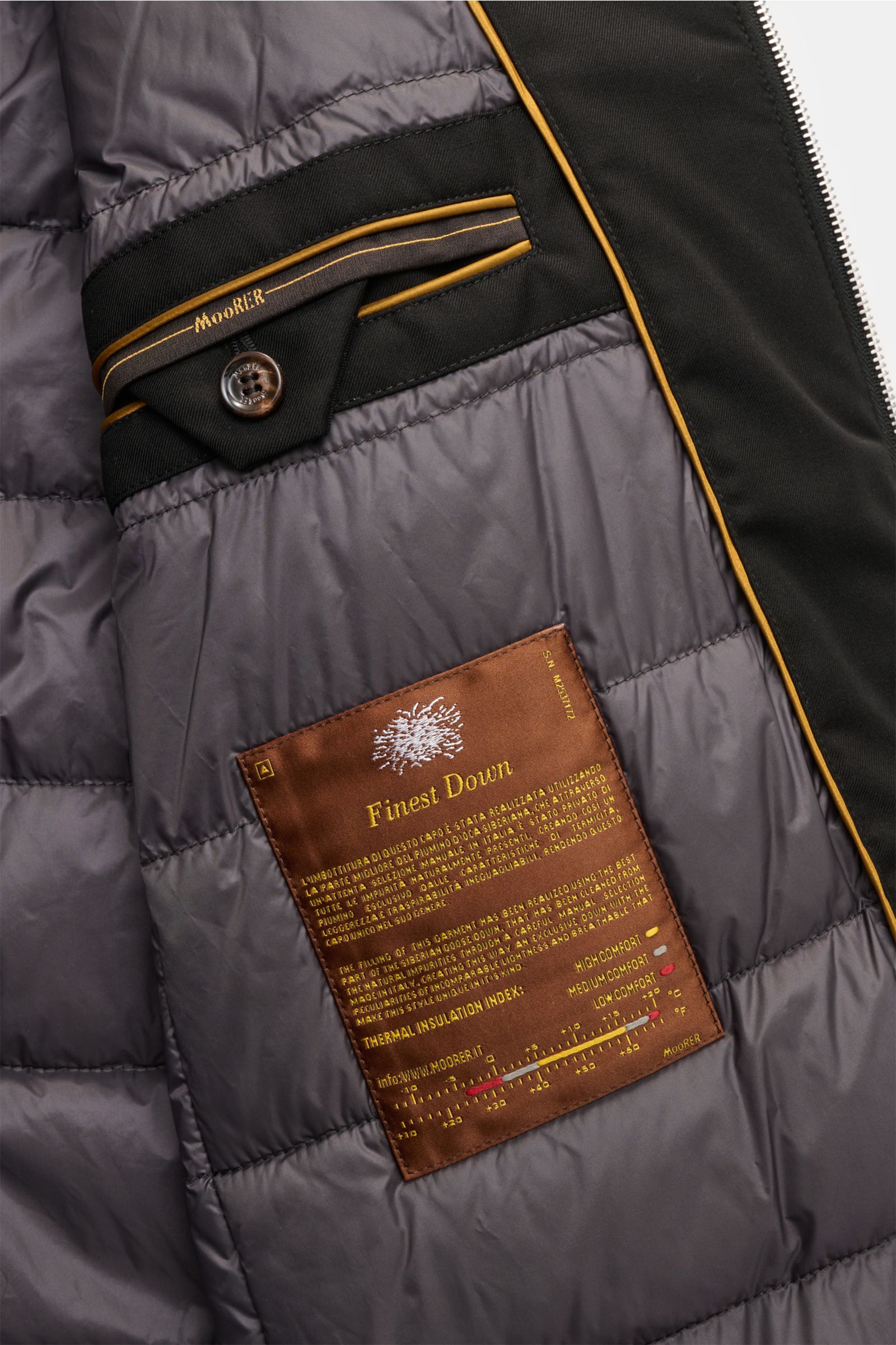 Nahaufnahme des Innenfutters der Moorer Daunenjacke 'Albini' schwarz mit gestepptem Futterstoff, Innentaschen und Markenlabel.
