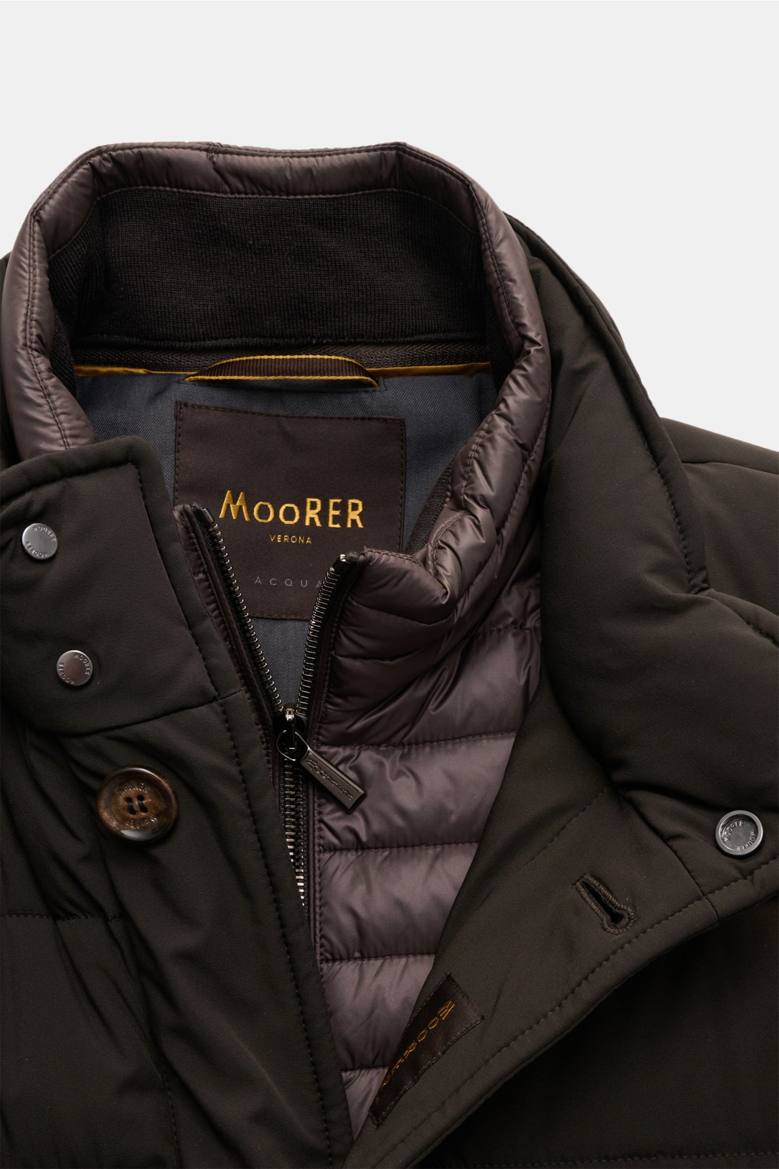 Nahaufnahme der Moorer Daunenjacke 'Calegari' graubraun von schräg oben, wasserabweisend mit Gänsedaunenfüllung, Slim Fit, Stehkragen und Knopfleiste.