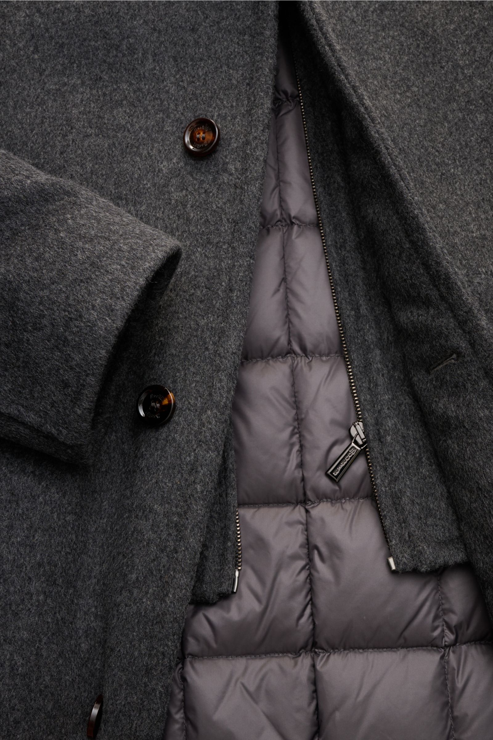 Close-up top-down view of the Moorer Down jacket 'Bond' grey mottled showing wool-cashmere blend outer, padded double front with buttons, and quilted warm down inner lining with zipper.

Italian tailoring meets functionality: This down jacket by MOORER ke