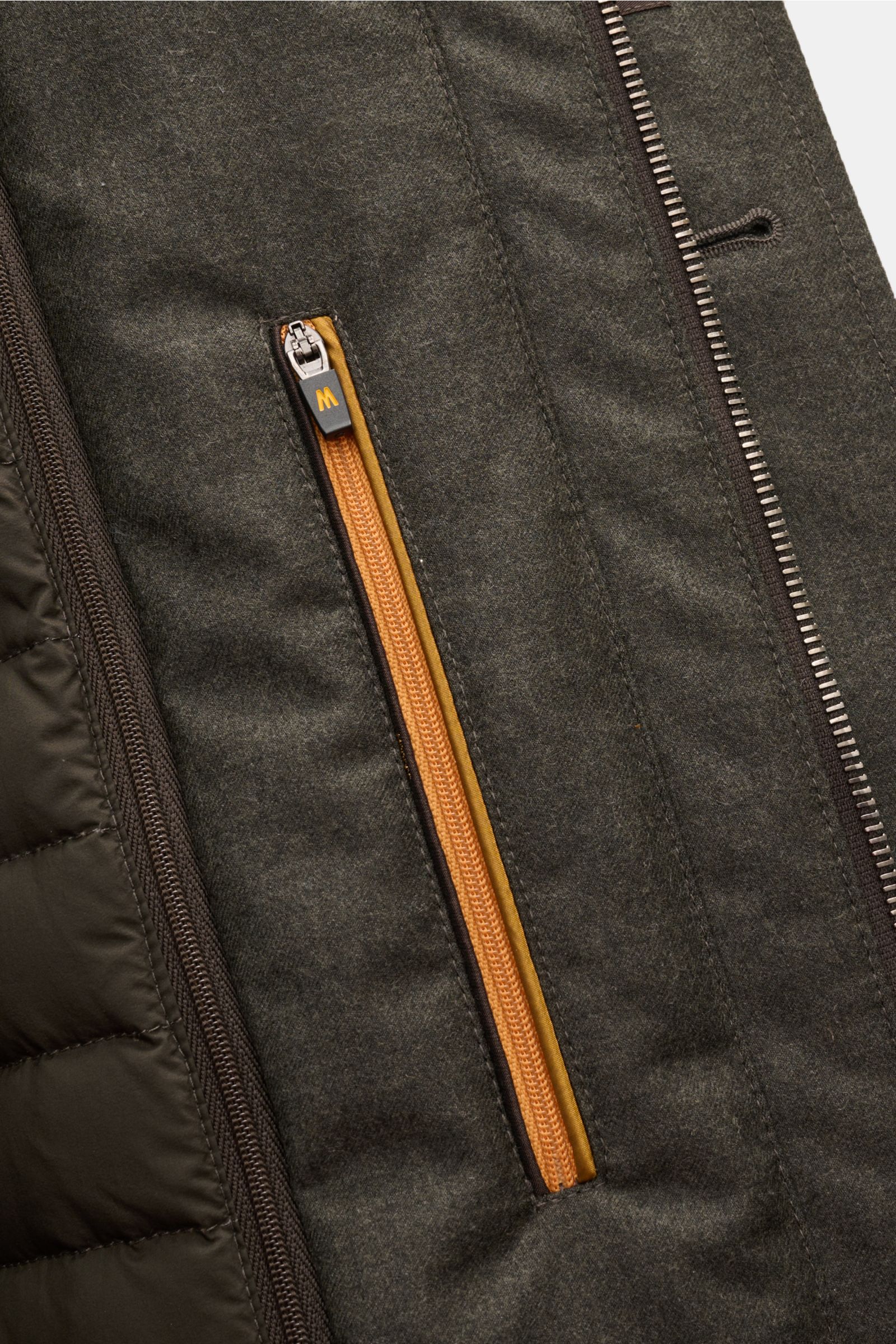 Close-up front view of Moorer Daunenjacke 'Isac' oliv meliert showing olive melange wool blend fabric with orange zipper pocket.

Stilvoll durch kalte Tage: Die Jacke 'Isac' von MOORER überzeugt mit einem edlen, wasserabweisenden Schurwoll-Mix und eine