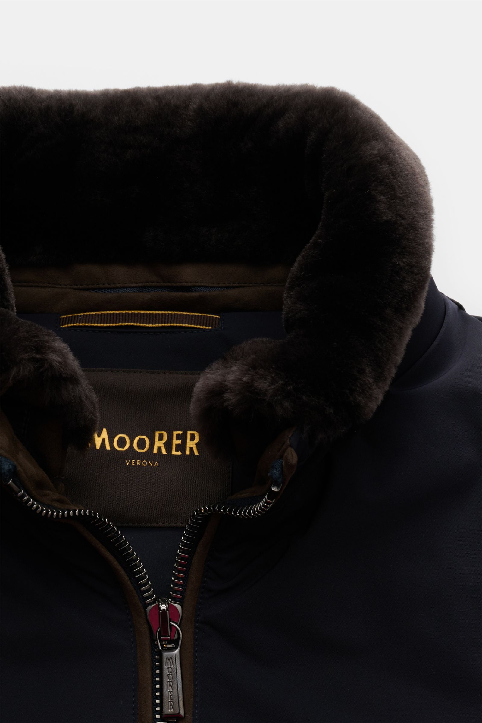 Nahaufnahme des Moorer Daunenblouson 'Celotti' dark navy von vorne, mit abnehmbarem Fellbesatz am Stehkragen, robuster Zwei-Wege-Reißverschluss, glattem Microfasergewebe, leichter Daunenfüllung, Slim Fit, Zipper-Fronttaschen, elastischen Saum- und Ärmelbü