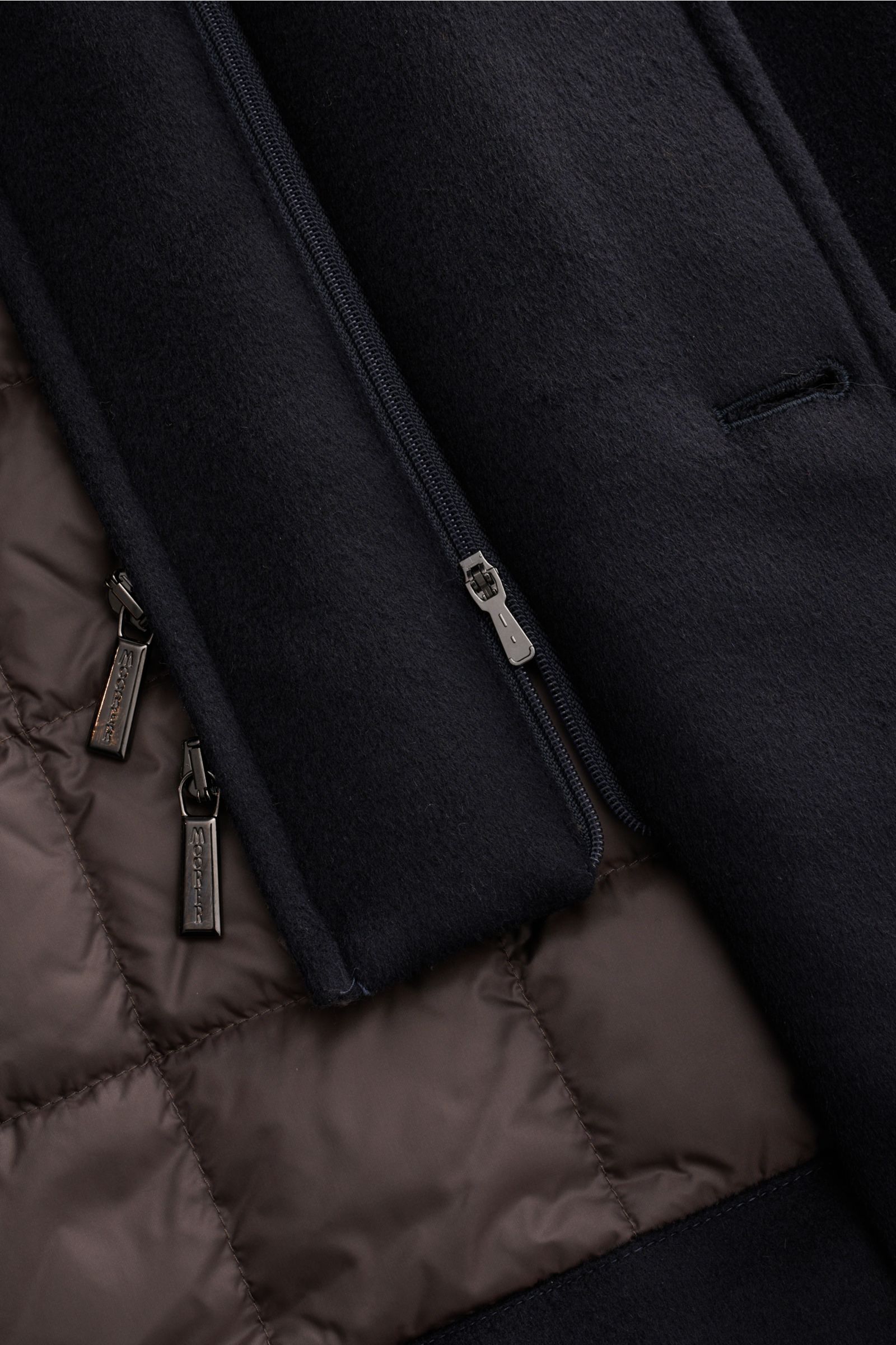 Close-up front view of the Moorer Cashmere Daunenjacke 'Mendel' navy, showing soft pure cashmere exterior, warm quilted brown down-filled lining, dual zippers with branded pulls, and detailed stitching. Understated luxury with removable double-front, slim