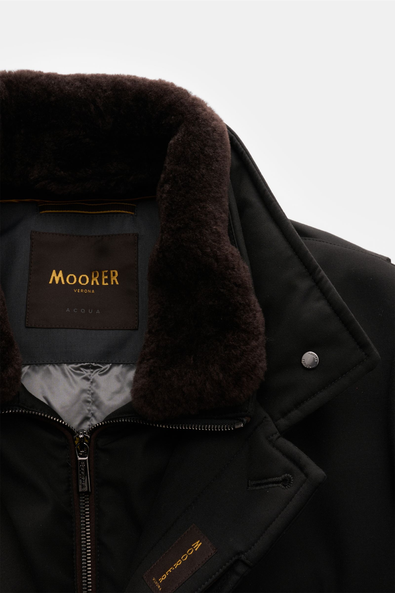 Close-up front view of Moorer Daunenjacke 'Drive Pum' schwarz with soft dark brown fur collar, zipper, and black microfiber shell, wind- and water-resistant.

Stilvoller Begleiter für kalte Tage: Wind- und wasserabweisend bietet die Daunenjacke von MOO