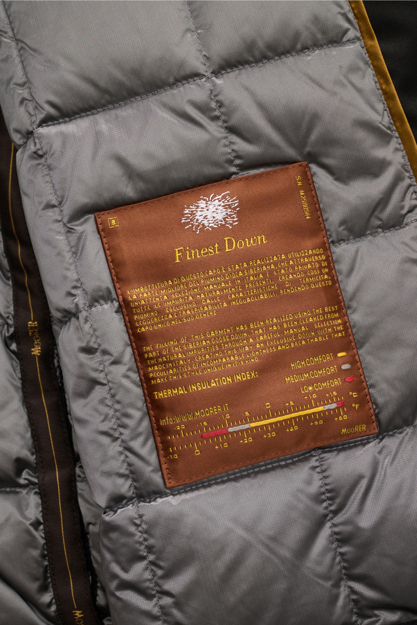 Close-up interior view of Moorer Daunenjacke 'Drive Pum' schwarz showing gray quilted lining and brown label with finest down and thermal insulation index.