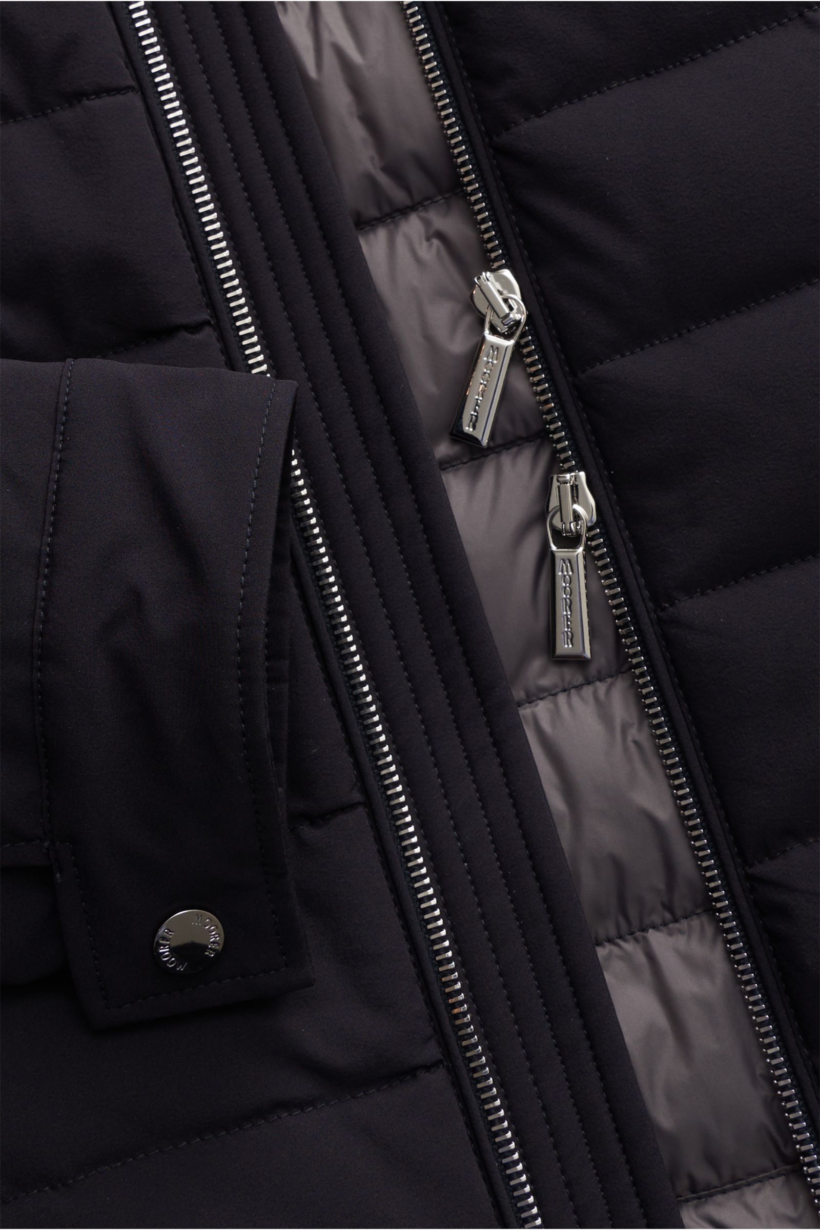 Nahaufnahme der wasserabweisenden Moorer Daunenjacke 'Filippo' dark navy mit zwei-Wege-Reißverschluss und Druckknopfärmeln.