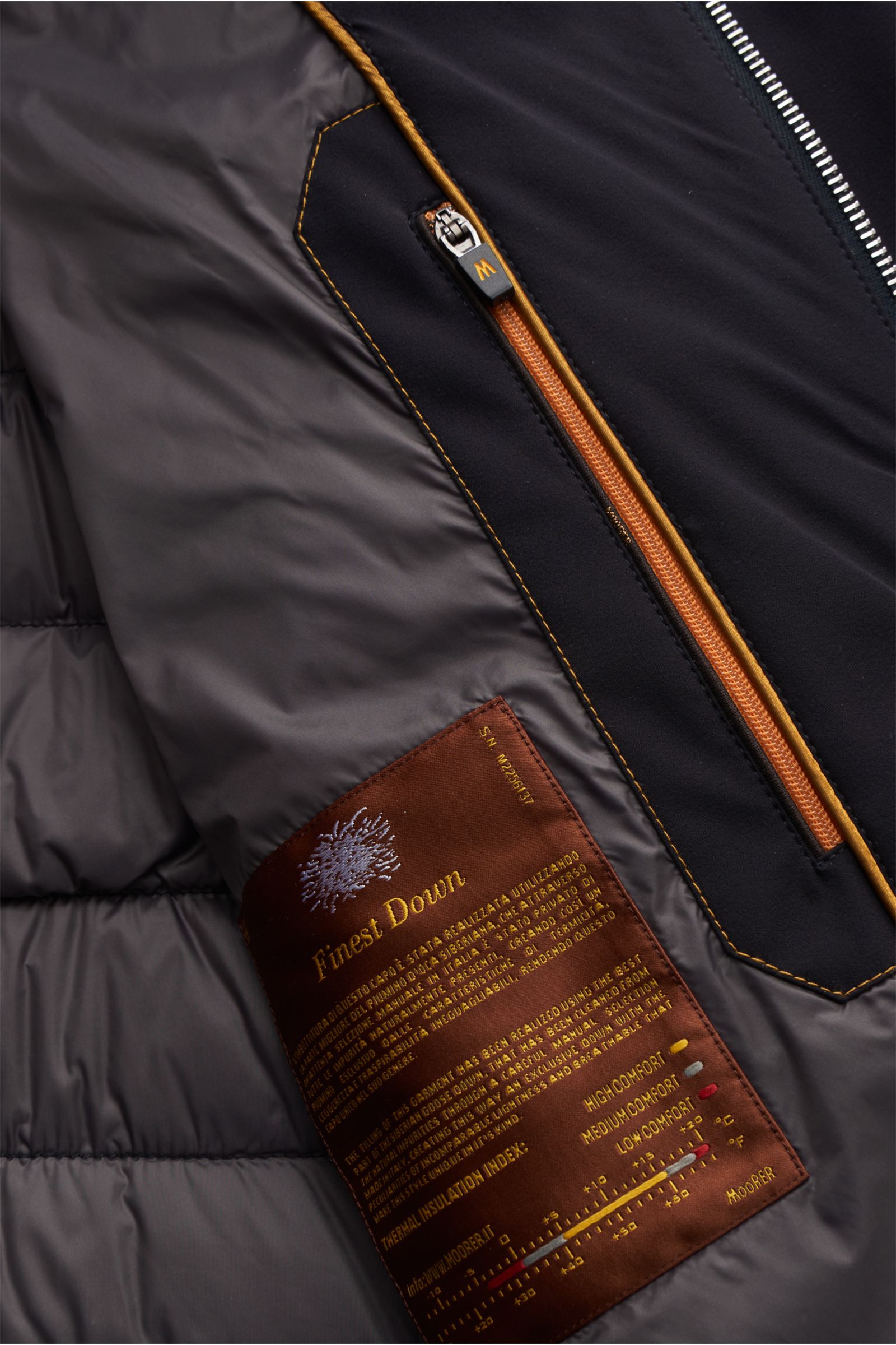 Nahaufnahme der Innenseite der Moorer Daunenjacke 'Filippo' dark navy mit wasserabweisender Microfaser, verstaubarer Kapuze, Reißverschluss und Daunenfüllung.