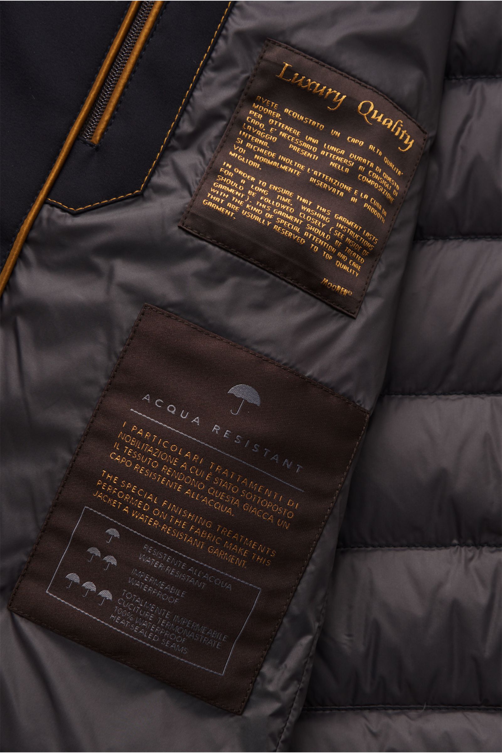 Innenansicht der Moorer Daunenjacke 'Filippo' dark navy mit wasserabweisendem glattem Futter, zwei Innentaschen und Luxury Quality Label.