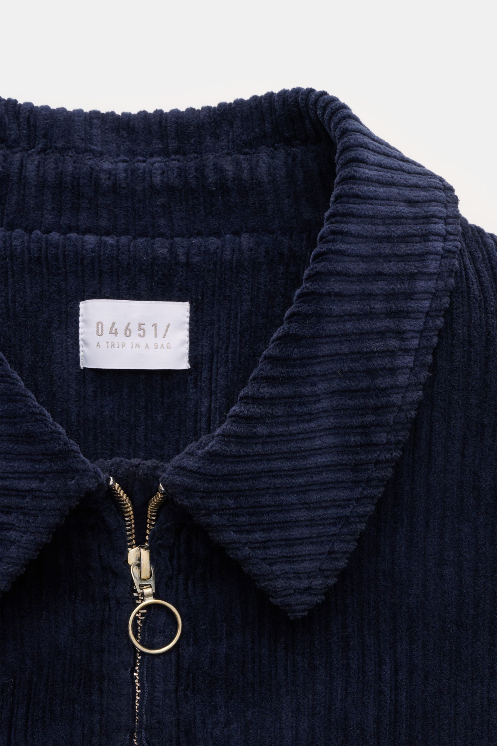 Nahaufnahme der 04651/ A trip in a bag Cordjacke navy mit Umlegekragen und Metall-Reißverschluss, weiche elastische Baumwolle, Cordstruktur von oben fotografiert.