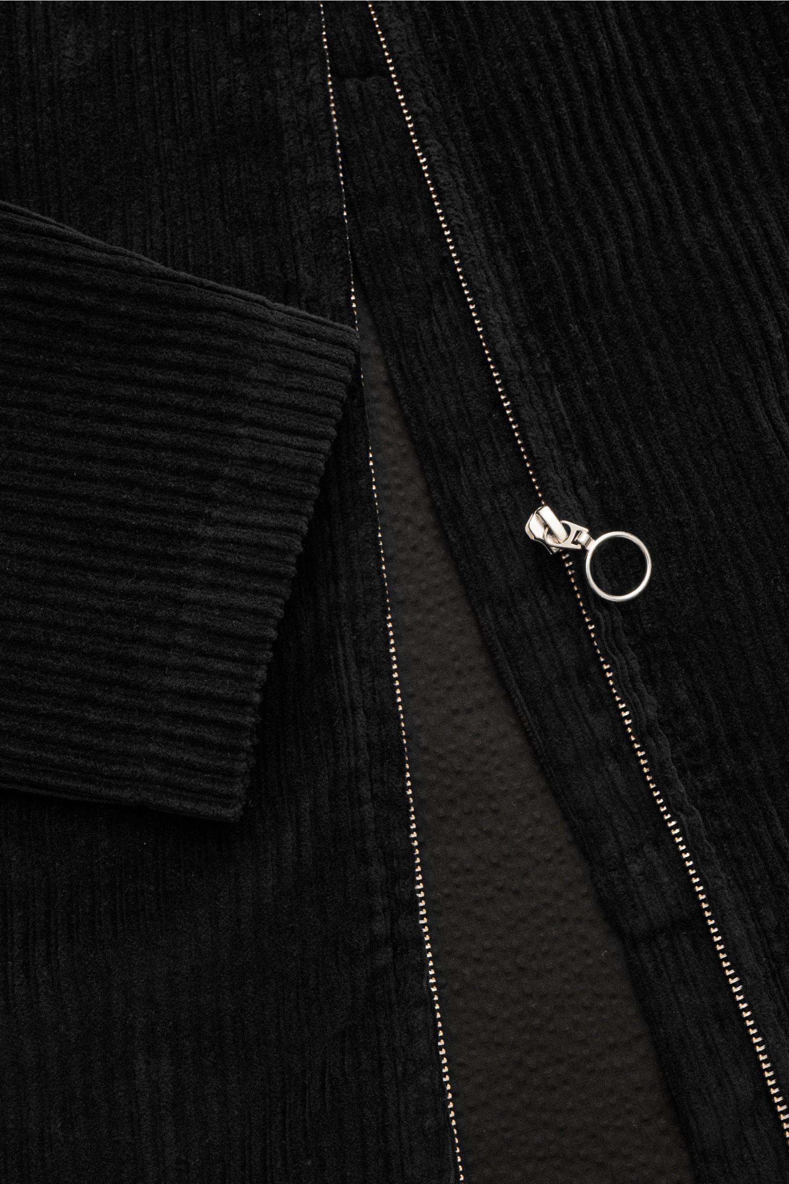 Schwarze 04651/ A trip in a bag Cordjacke aus elastischer Baumwolle mit Metall-Reißverschluss, Umlegekragen, paspelierten Taschen, weichem Griff, Regular Fit, Innentasche, von nah und schräg oben fotografiert.