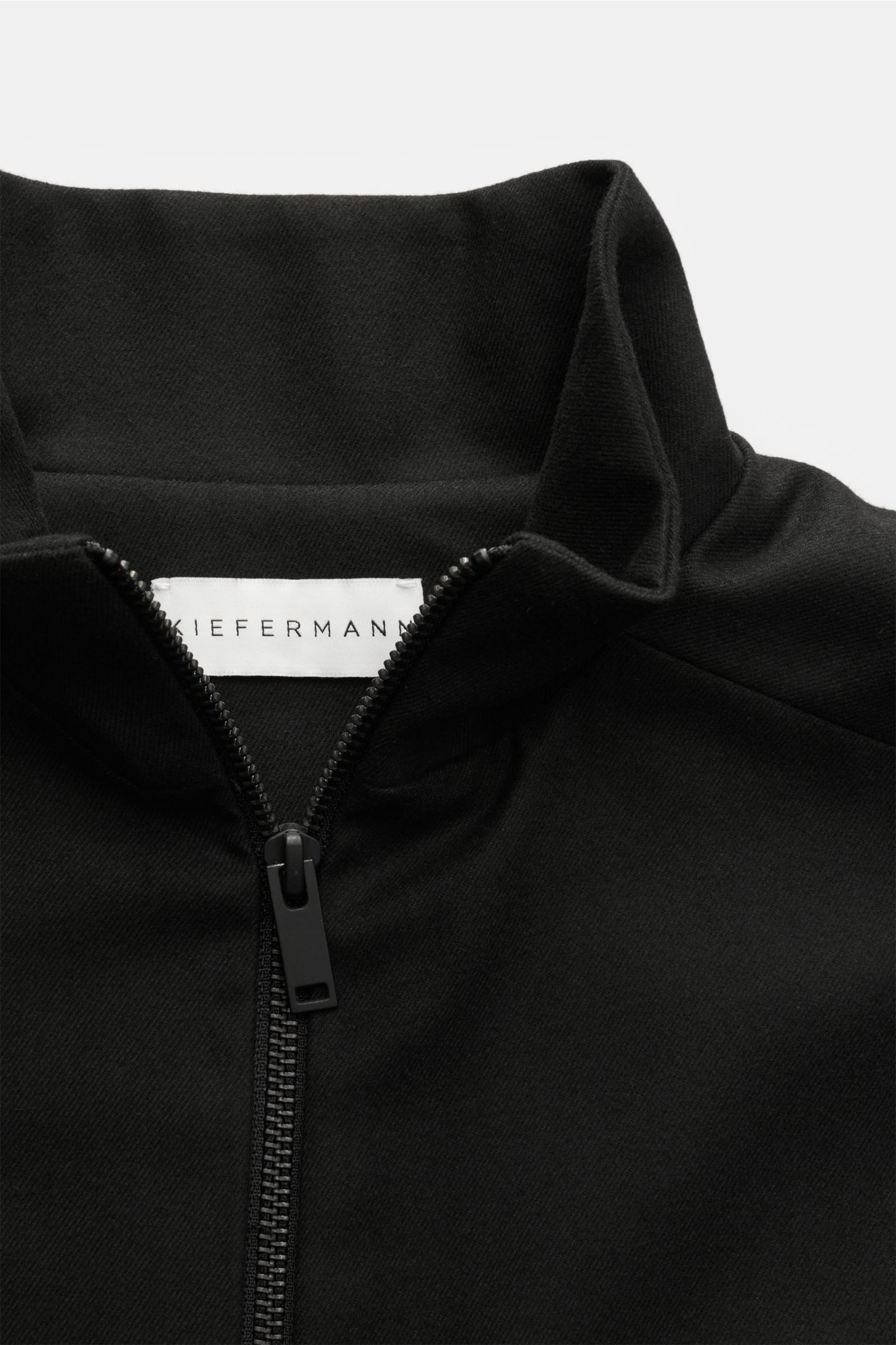 Close-up front view of the Kiefermann Jacke 'Josepp' schwarz showing the high stand-up collar, robust zipper, and fine twill texture. 'Josepp

Mix aus Viskose und Microfaser
leichter Stretch-Anteil
feine Twillstruktur
