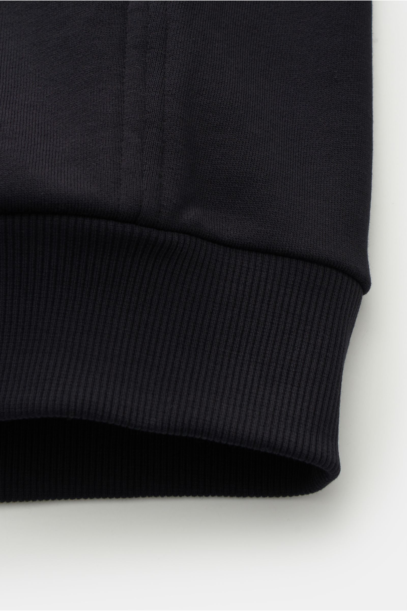 Close-up view of the ribbed band hem of the Moorer Sweat jacket 'Jaiden' dark navy, sweat made of pure cotton, soft feel, contrasting tuxedo stripes, regular fit, raglan sleeves, two-way zip, high-closing standing collar, slanted hip pockets with snap but