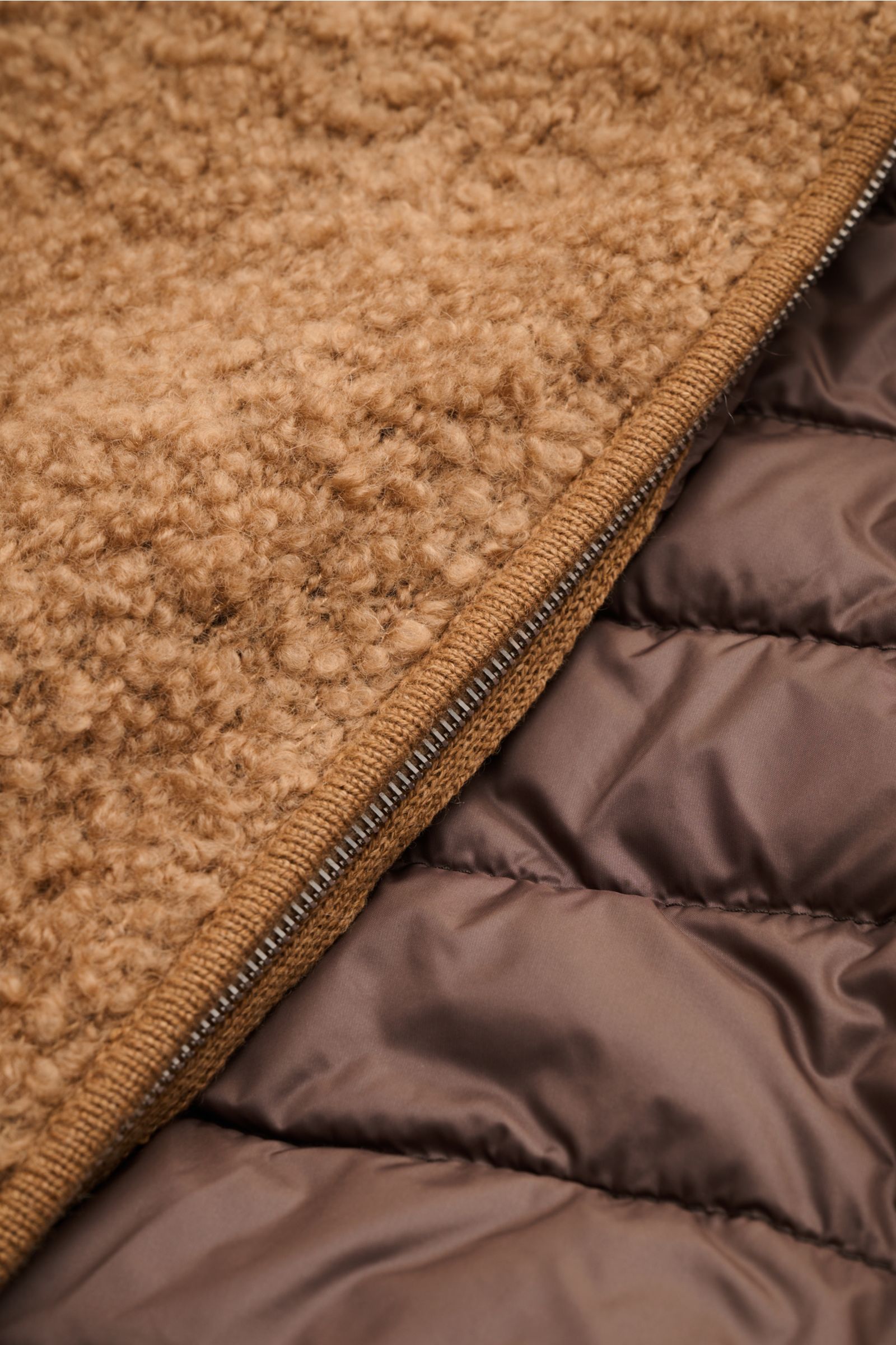 Nahaufnahme des geöffneten Moorer Daunenblouson 'Arena' camel von innen und außen, zeigt weiches Loop-Effektgarn aus Seide-Kamelhaar und leichte Daunenfüllung.