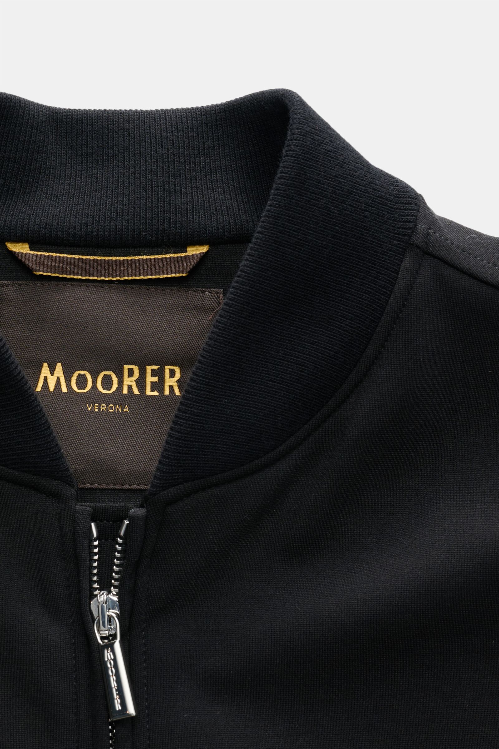 Close-up front top view of the black Moorer Blouson 'Astaire' schwarz showing the rib-knit collar, two-way zipper, and interior label; sportive styles in autumn, made from a viscose and microfiber mix with a soft feel, slim fit, typical rib-knit blouson c