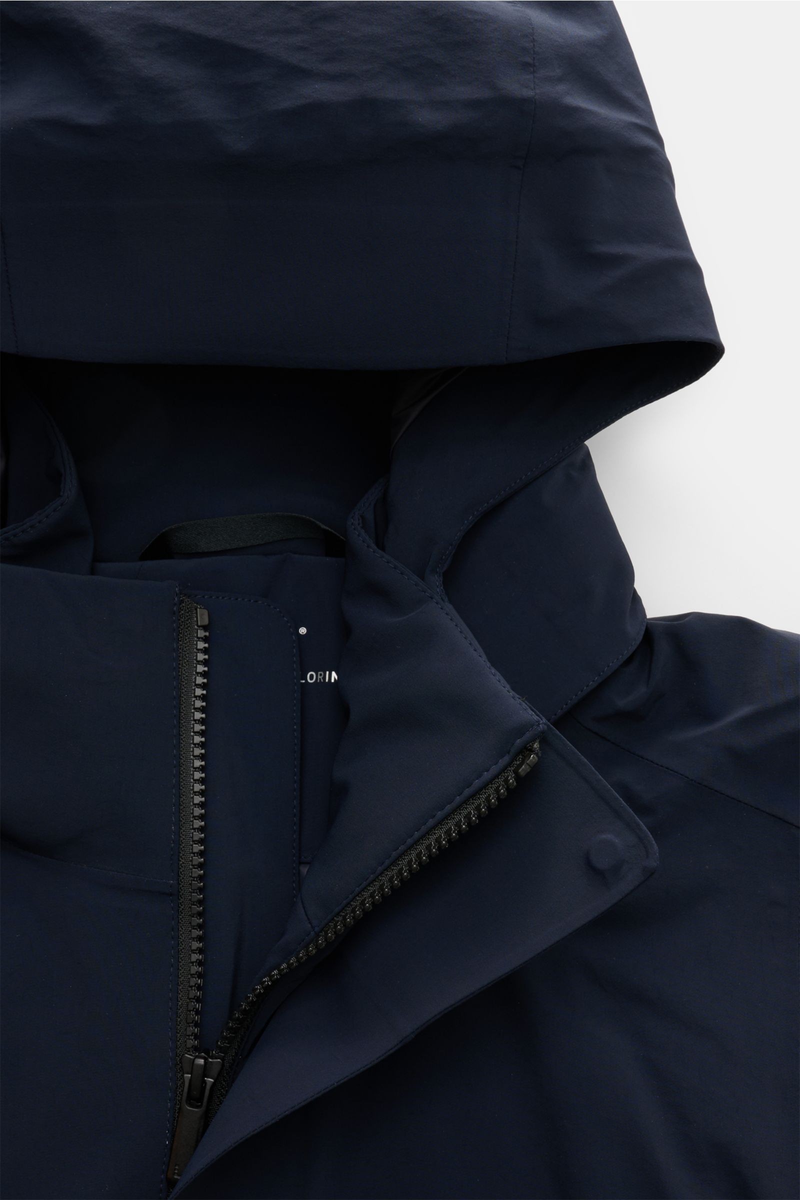 Close-up front view of the UBR Parka 'Regulator' navy showing the high collar, partially open black zipper, and attached hood with clean stitching.

High-Tech-Materialien und innovative Fertigungstechniken sind das Fachgebiet der norwegisch