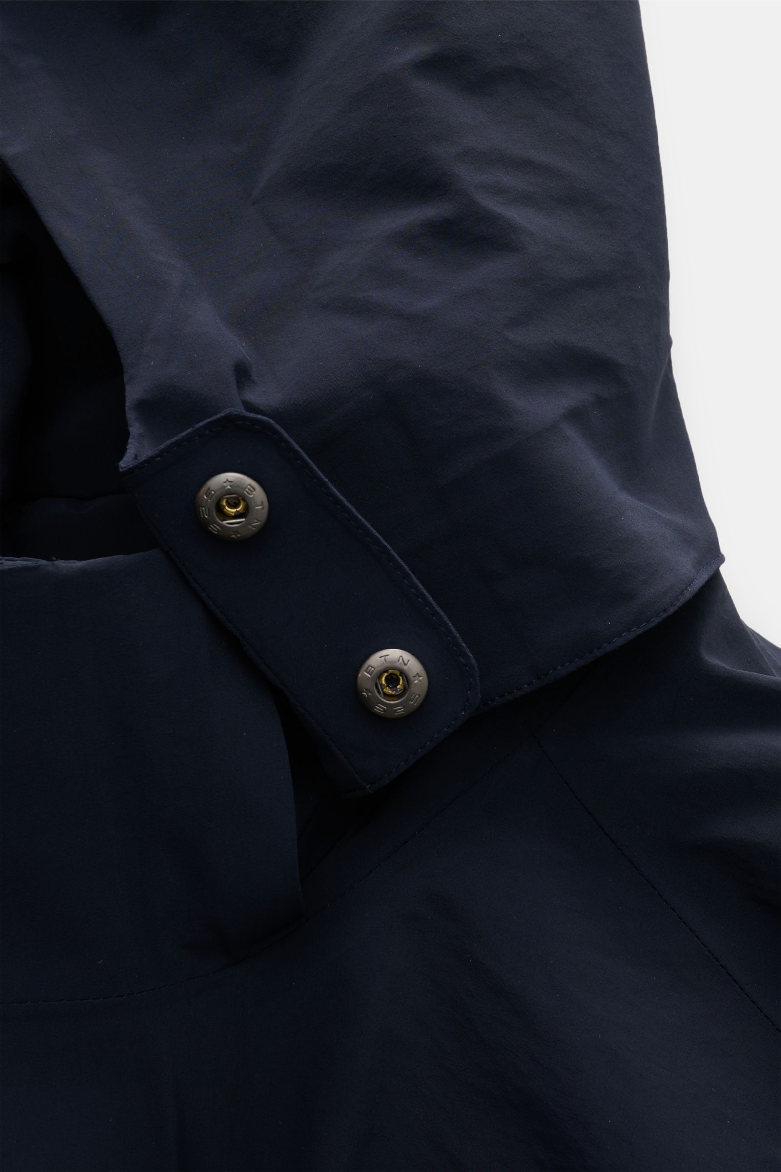 Close-up view of the UBR Parka 'Regulator' navy showing the high-tech microfiber fabric and detailed snap button on the detachable hood.

High-Tech-Materialien und innovative Fertigungstechniken sind das Fachgebiet der norwegischen Marke UB