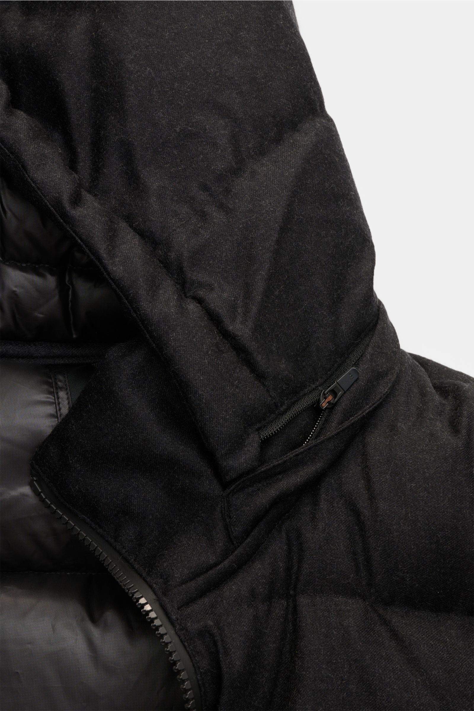 Detailaufnahme der UBR Daunenjacke 'Concord' schwarz mit wattierter, abnehmbarer Kapuze und Zwei-Wege-Reißverschluss, weiche Wolloberfläche.