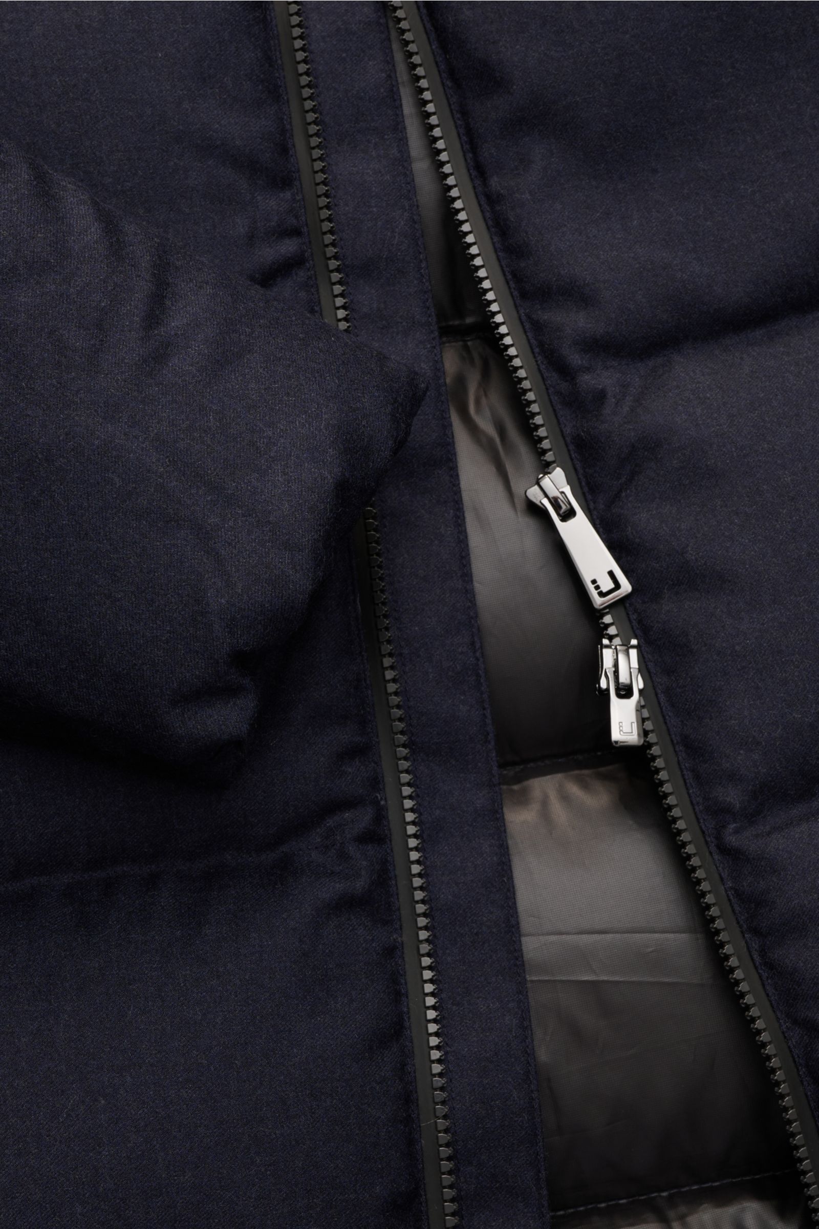 Close-up front view of UBR Daunenjacke 'Concord' navy meliert with two-way zipper, soft wool fabric, and padded down filling.