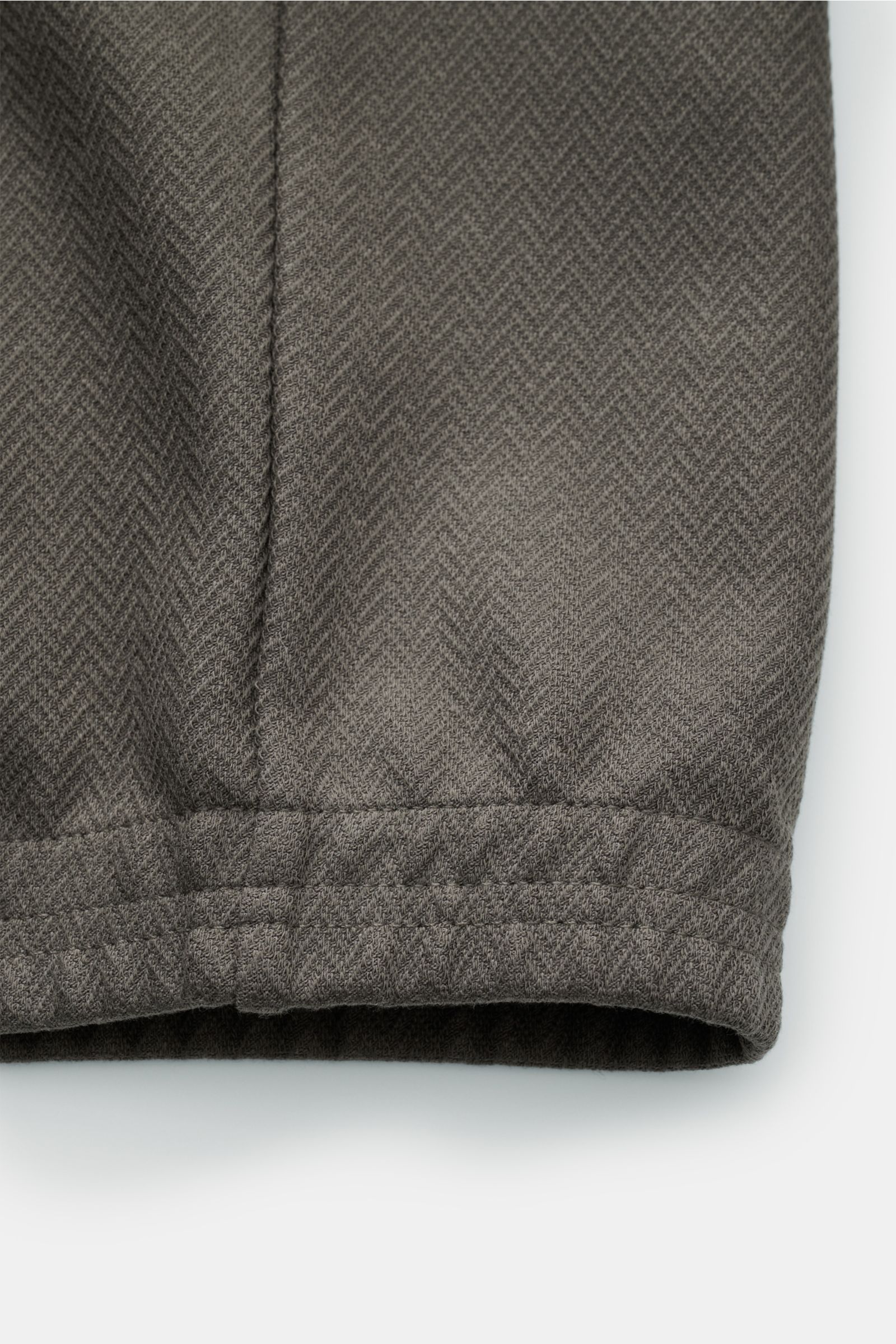 Close-up of the elastic hem of the Emporio Armani Blouson grey-green, showcasing lightweight robust cotton and Lyocell fabric with herringbone texture, photographed from the bottom front. Sporty and timeless: This blouson by EMPORIO ARMANI has a casual de