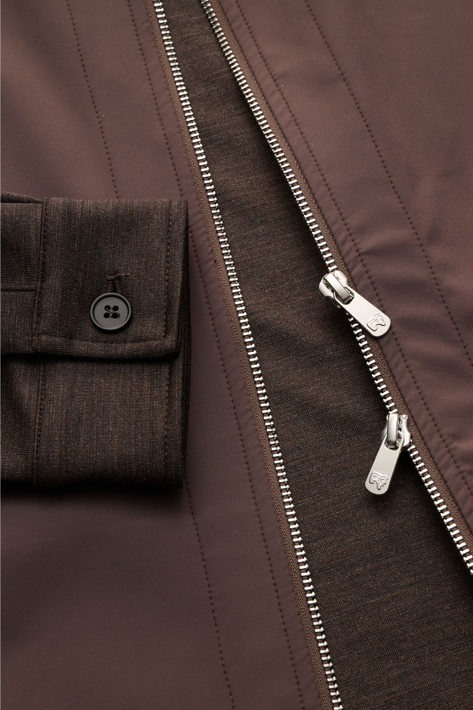 Nahaufnahme der Marco Pescarolo Jacke 'Key' dunkelbraun mit zwei-Wege-Reißverschluss, Knopfmanschette und Jersey-Ärmeln aus schurwolle.