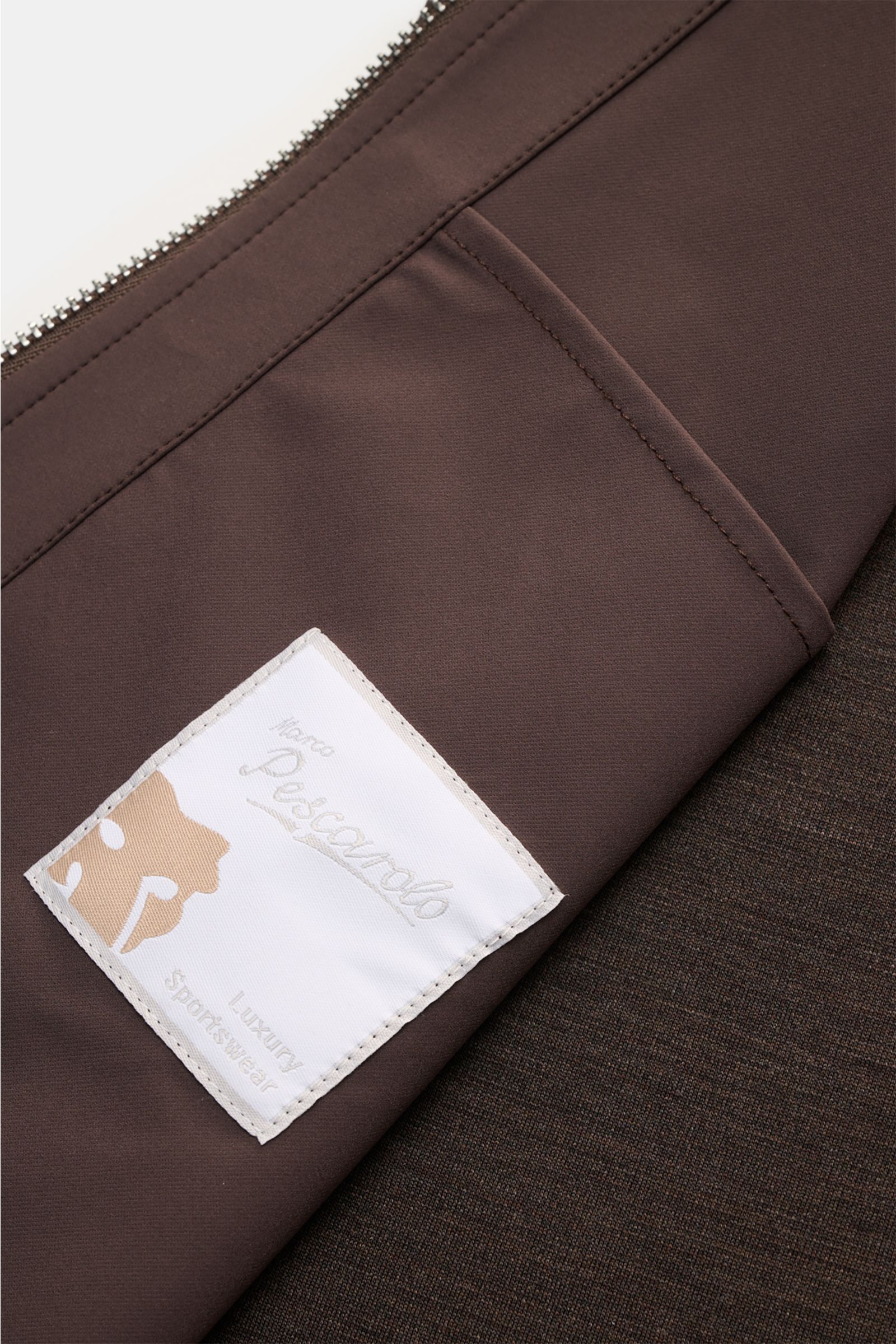 Marco Pescarolo Jacke 'Key' dunkelbraun, Detailaufnahme von Ärmeln und Rückenteil aus elastischem Jersey mit Markenlabel, ungefüttert, Regular Fit.