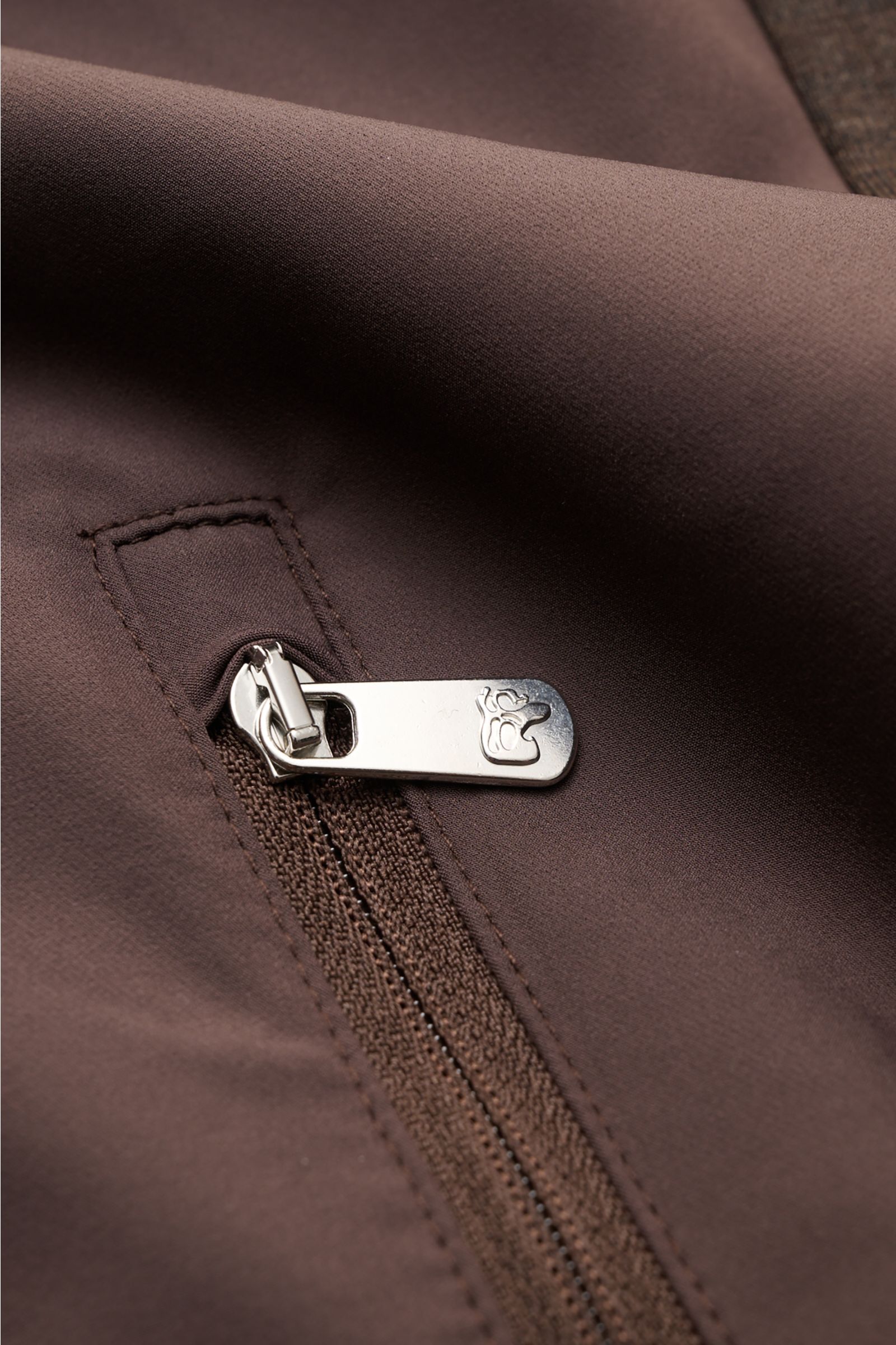 Marco Pescarolo Jacke 'Key' dunkelbraun, Nahaufnahme von Zipper-Fronttasche und elastischem Jersey-Ärmel mit robuster Verarbeitung.