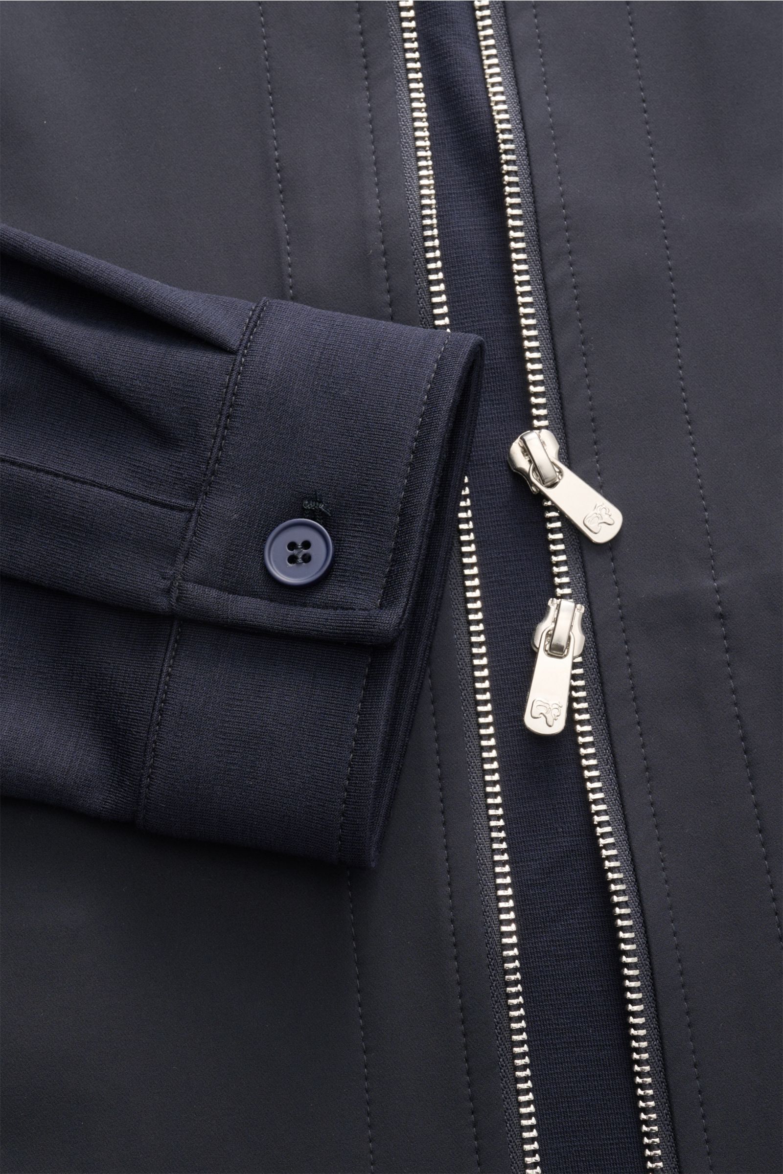 Alt tag (125 characters): Close-up front view of Marco Pescarolo Jacke 'Key' navy showing zipper, buttoned cuff, and jersey fabric details.

Additional description: 
Ihre sportive Optik verdankt die Jacke 'KEY' von MARCO PESCAROLO den Ärmeln und dem Rü