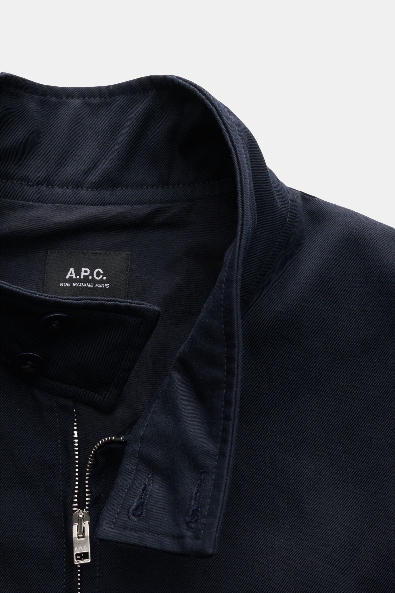 Close-up front view of A.P.C. Blouson dark navy made of pure cotton gabardine with concealed zip, buttoned standing collar, and tonal stitching.

Description: Distinctive, urban and clean: This blouson by A.P.C. plays with clear shapes. High-quality co