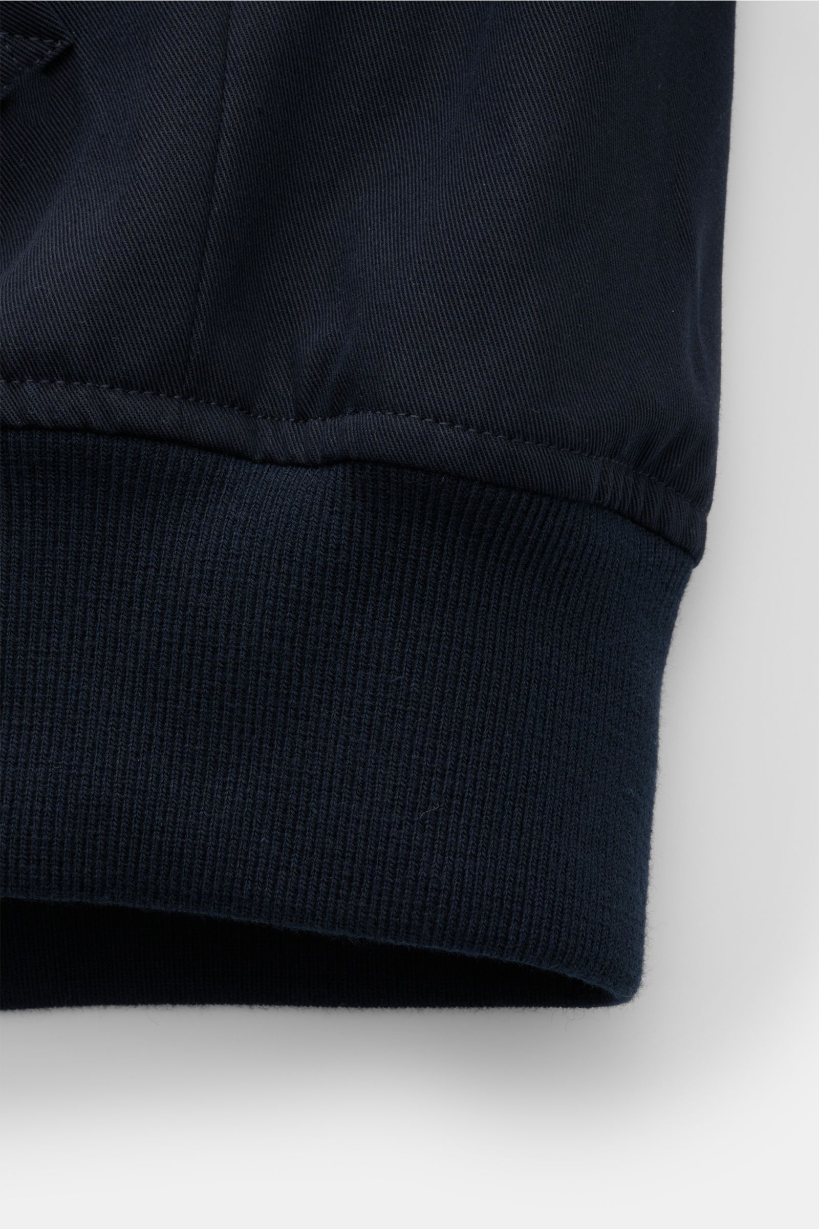 Close-up detail of the elastic hem of the A.P.C. Blouson dark navy, photographed from the side showing the fine cotton gabardine fabric and ribbed knit cuff.

Distinctive, urban and clean: This blouson by A.P.C. plays with clear shapes. High-quality co