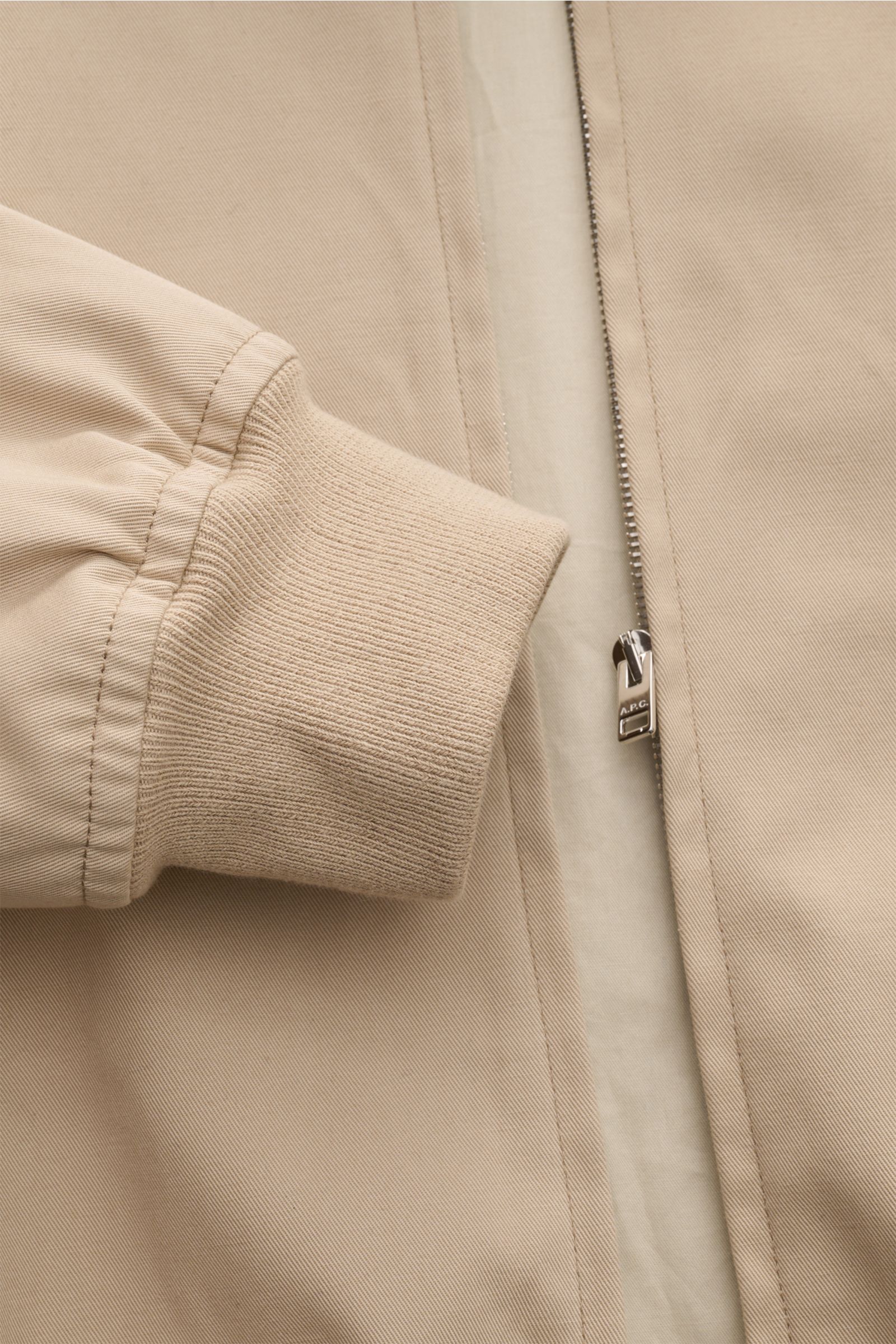 Close-up front view of the beige A.P.C. Blouson showing ribbed sleeve cuff, concealed zip with tonal stitching on cotton gabardine fabric.

Distinctive, urban and clean: This blouson by A.P.C. plays with clear shapes. High-quality cotton gabardine and 