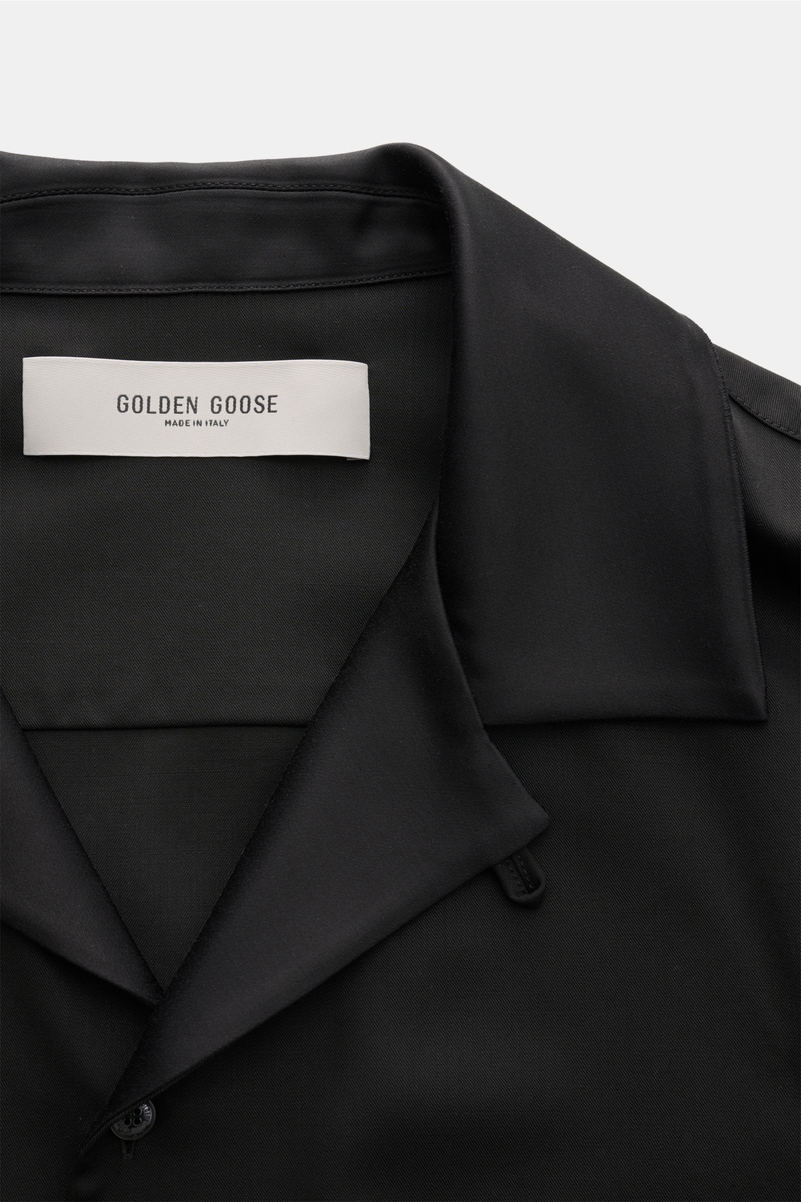 Close-up front view of the collar and label of the black Golden Goose Overshirt 'M's Tailored Shirt Paolo W Camp' in fine virgin wool twill with satin highlights.