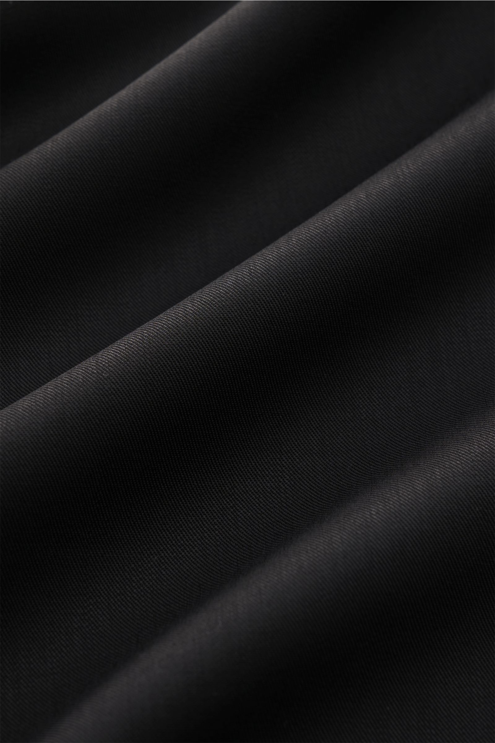 Close-up of black twill fabric texture, showing fine virgin wool weave with soft, smooth feel, for Golden Goose Overshirt 'M's Tailored Shirt Paolo W Camp' black, photographed from above. Uncomplicated, individual, GOLDEN GOOSE: This overshirt in fine vir