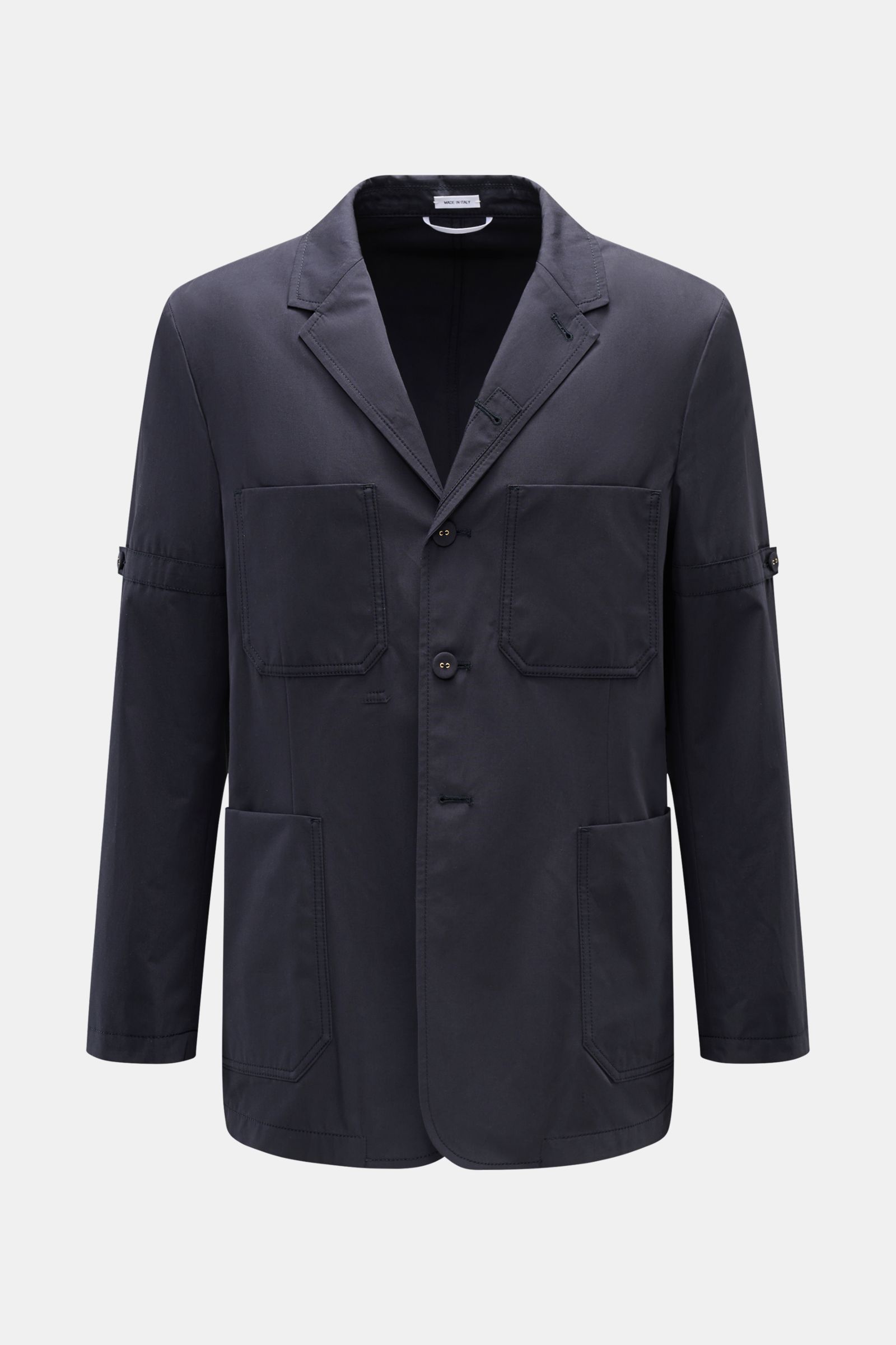 Front view of Thom Browne Jacket navy in slim fit pure cotton with four-button placket, adjustable collar, four front pockets, sleeve tabs, and waist tab.

Elegant outdoor essential: The THOM BROWNE jacket impresses with the timeless design of a smart-