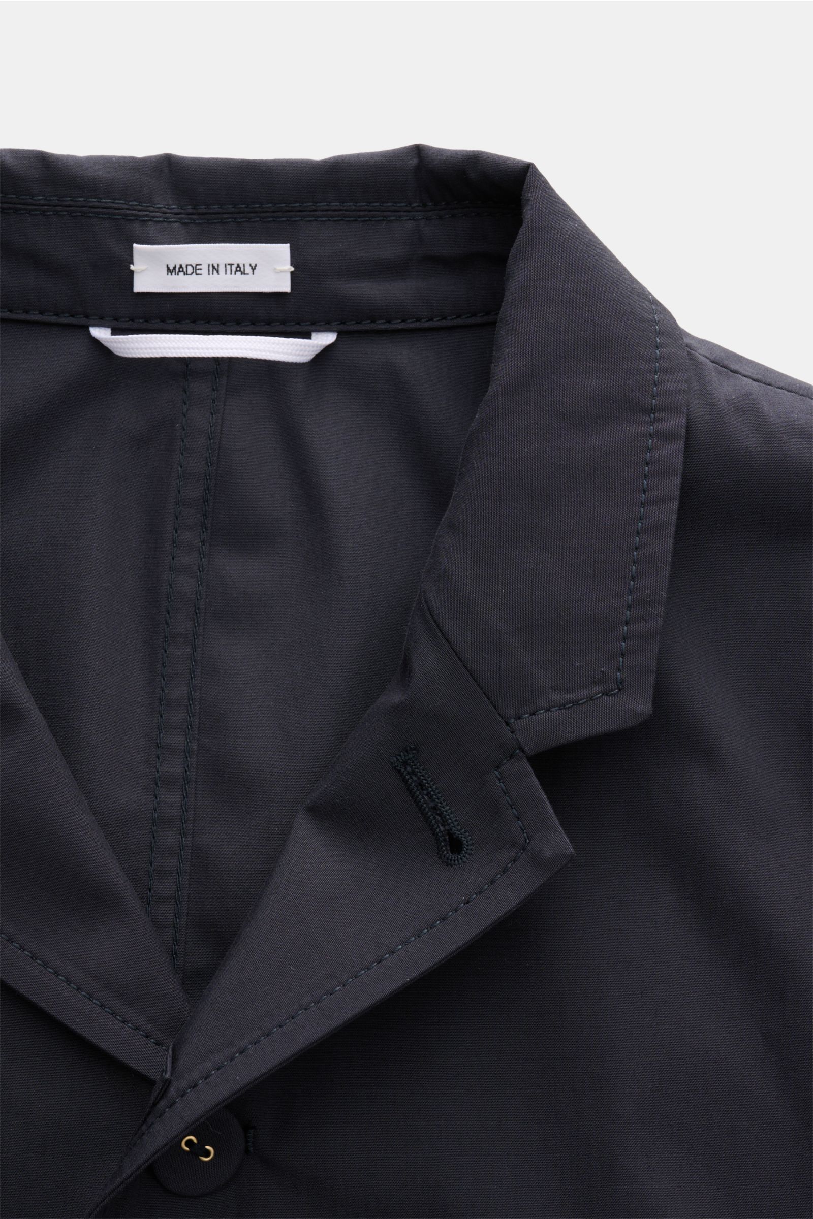 Close-up front top view of the Thom Browne Jacket navy collar and lapel, showing fine stitching and buttonhole detail.

Elegant outdoor essential: The THOM BROWNE jacket impresses with the timeless design of a smart-casual jacket, making it a strikingl