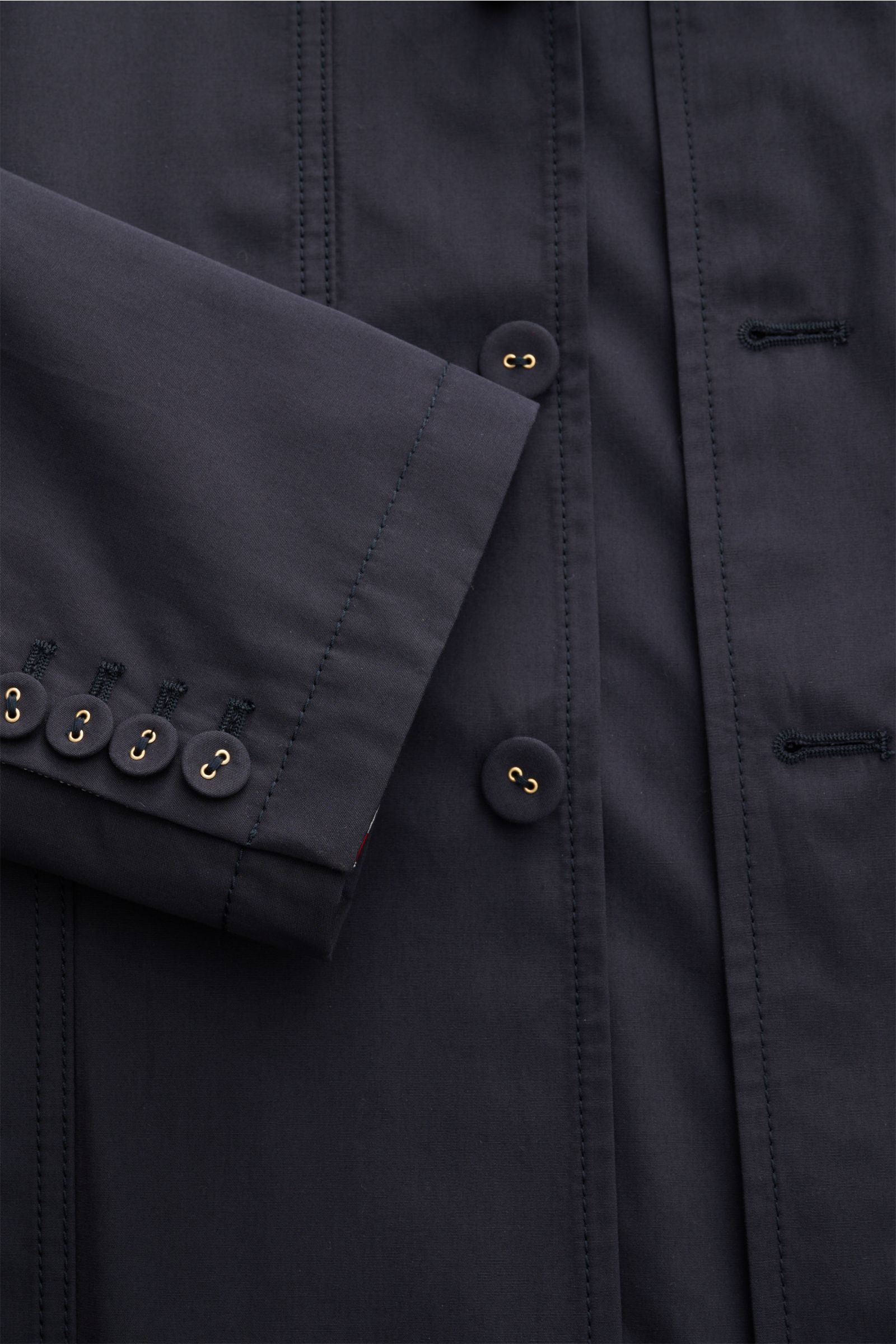 Close-up front view of Thom Browne Jacket navy showing four-button placket, sleeve ends with kissing buttons, and detailed stitching.

Elegant outdoor essential: The THOM BROWNE jacket impresses with the timeless design of a smart-casual jacket, making