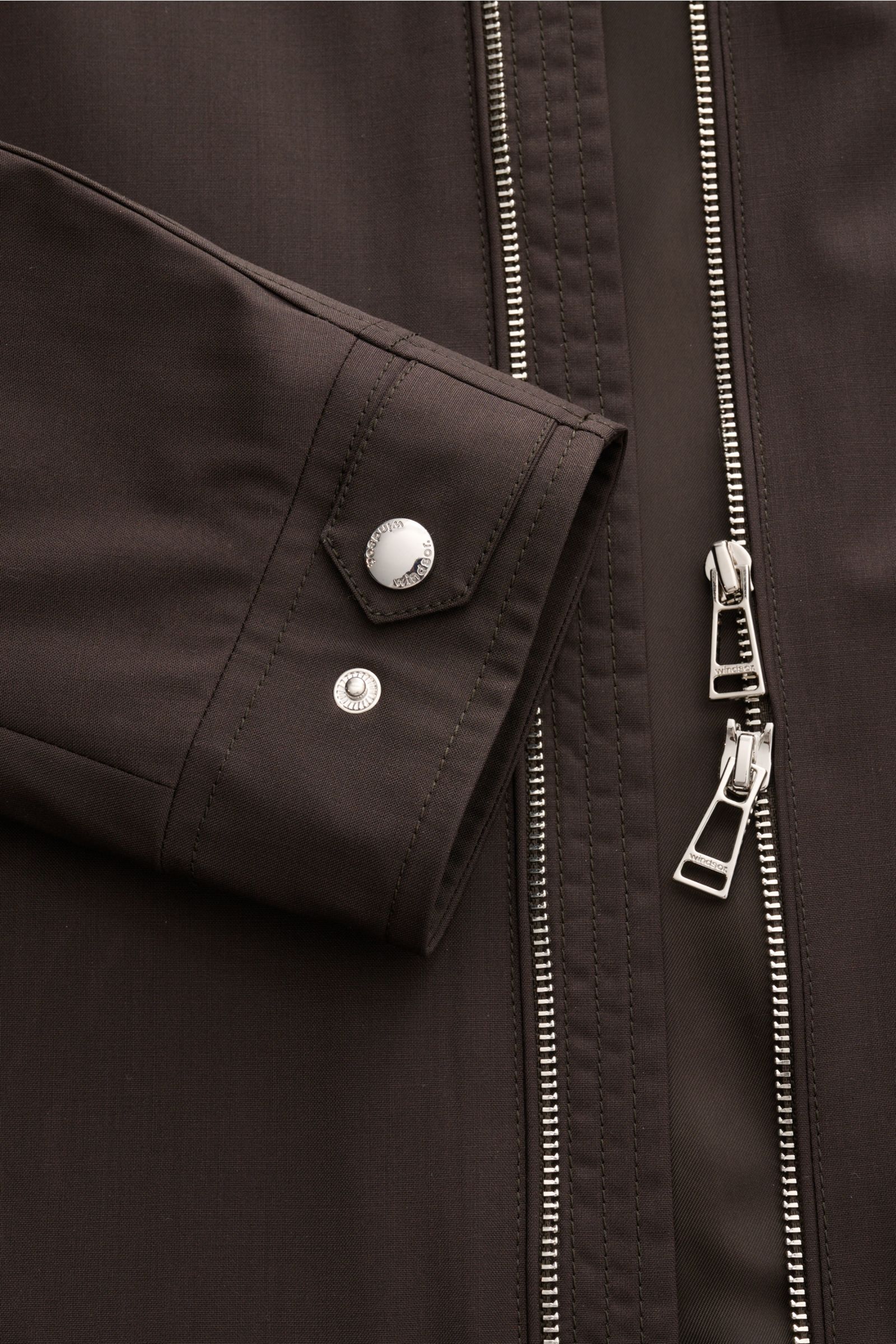 Close-up front view of the Windsor Blouson 'Attilio' dunkelbraun showing the sleeve cuff with snap buttons and the robust two-way zipper, made from lightweight pure virgin wool with tonal lining. 

Der Blouson 'Attilio' von WINDSOR aus Reda Active Wool