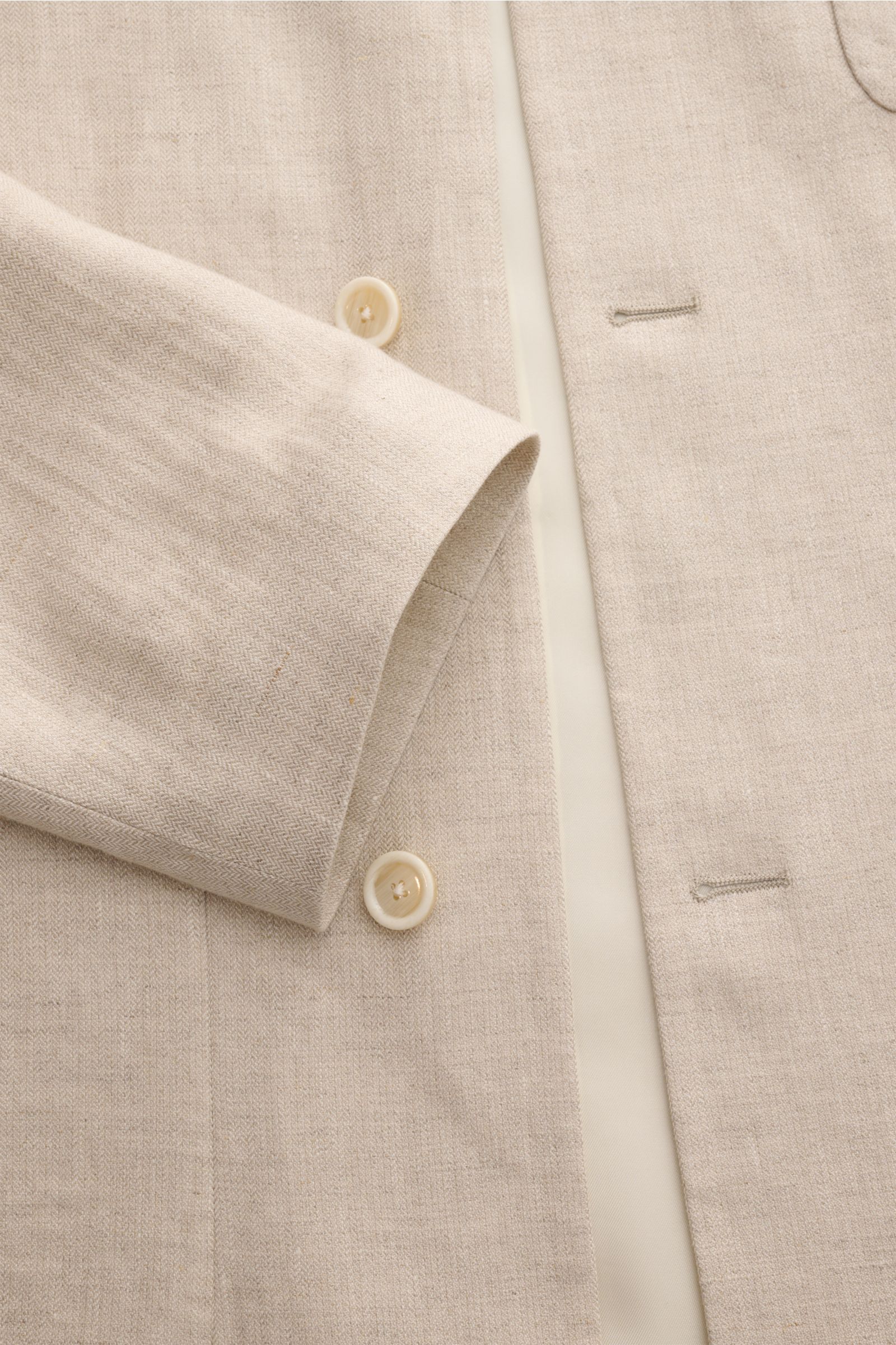 Lardini Leinenjacke 'Pastone' beige meliert, Detailaufnahme von Ärmel, Knöpfen und feinem Fischgrat-Gewebe aus reinem Leinen.