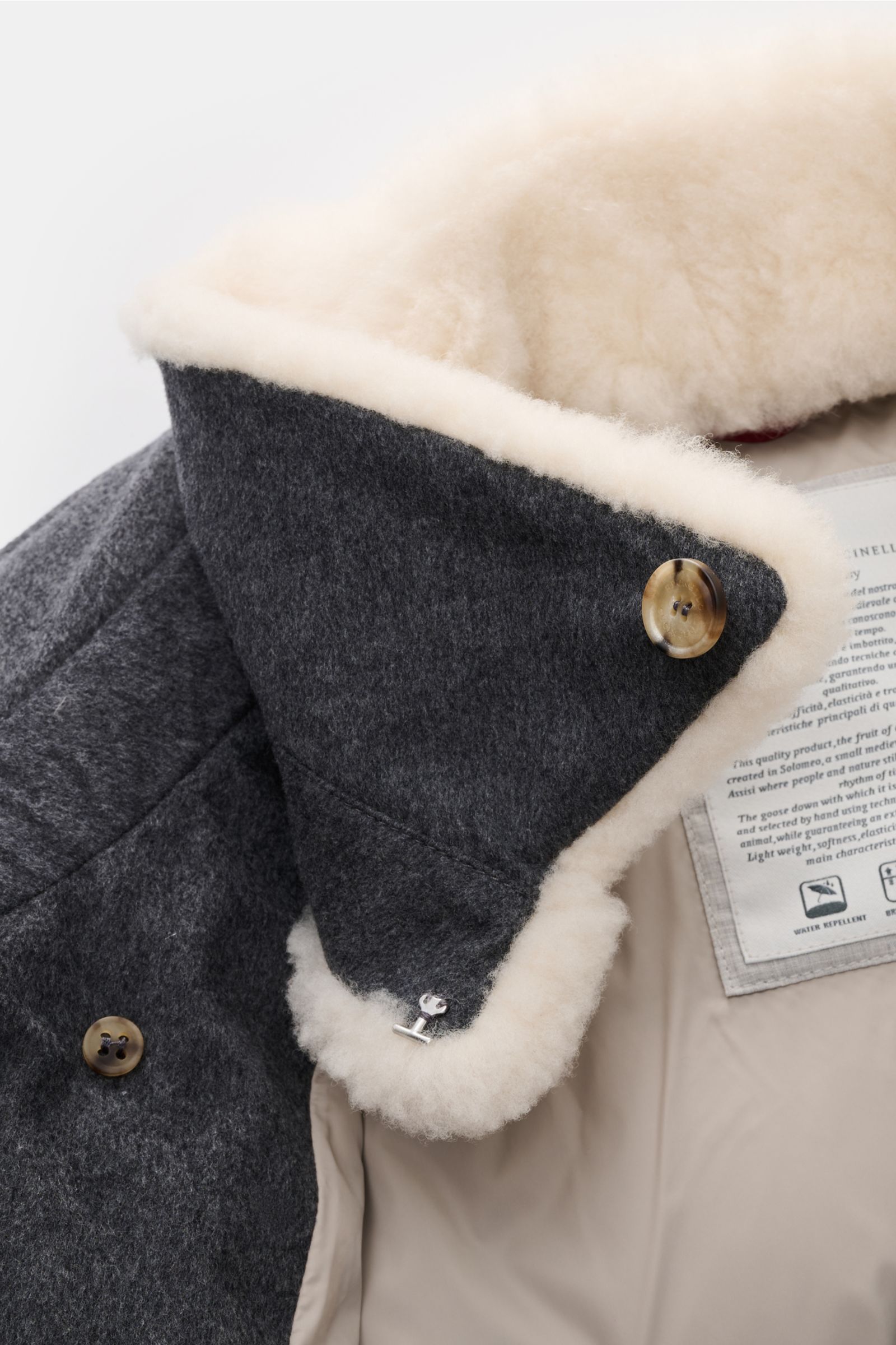 Brunello Cucinelli Daunenjacke dunkelgrau meliert, Detailaufnahme von innen am Kragen mit weichem Schaffellbesatz und Knöpfen, reine Wolle, Daunenfüllung.