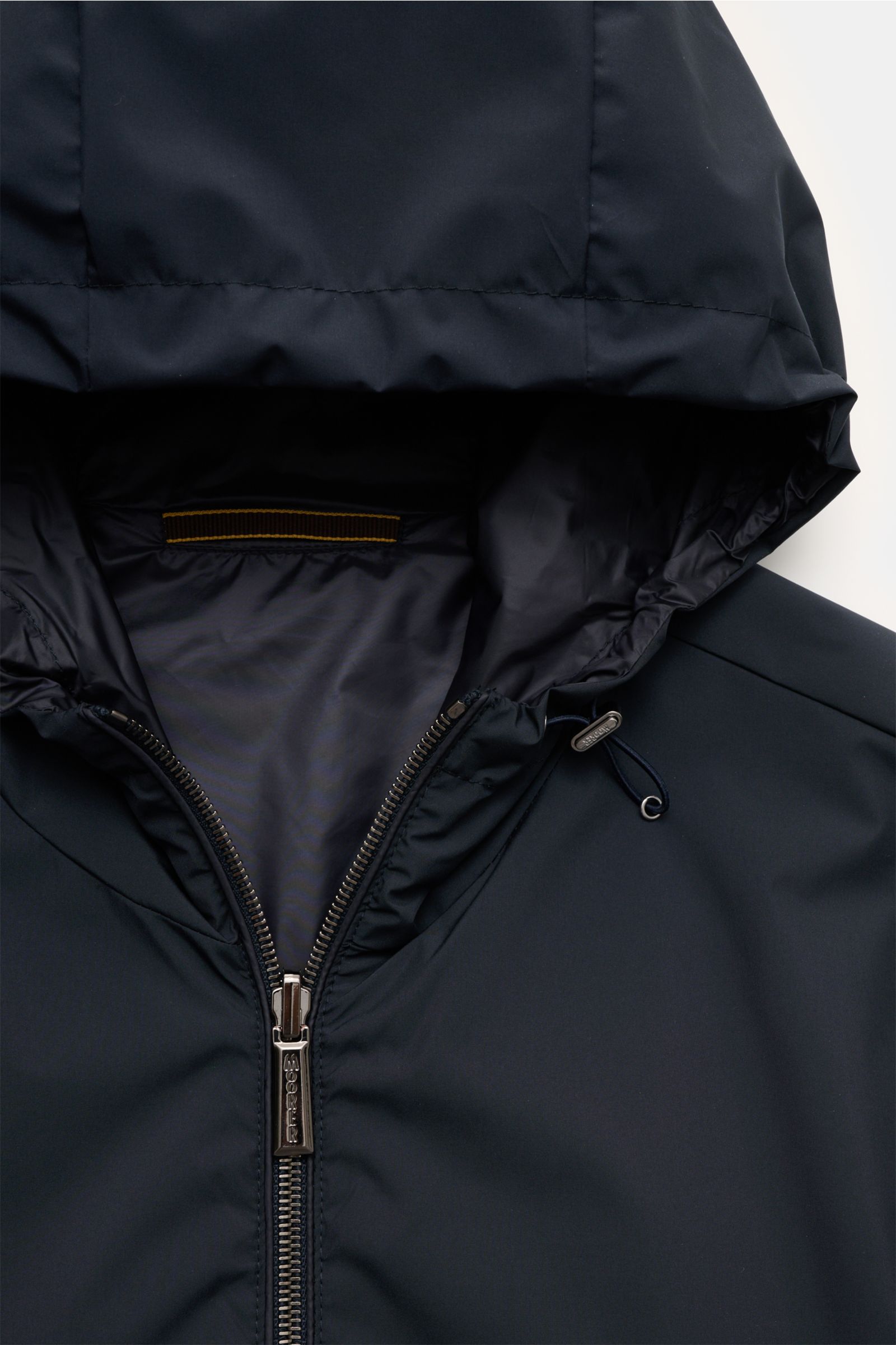 Close-up front view of Moorer Wende-Blouson 'Dennys' navy with high collar zipper, hood with drawstring, and smooth water-repellent microfiber fabric, showcasing slim fit and elastic hem and cuffs, highlighting its reversible design for flexible outdoor l