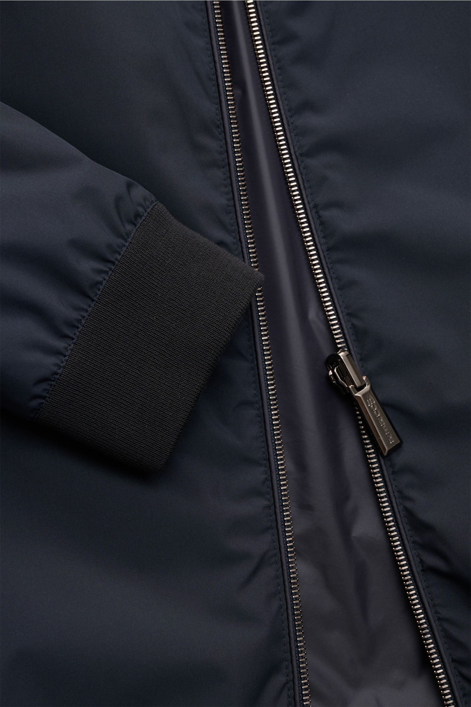 Close-up front view of the Moorer Wende-Blouson 'Dennys' navy showing water-repellent microfiber fabric, smooth texture, slim fit, elastic cuff, and high collar zipper. Funktionaler Outdoor-Luxus: Mit seinem wendbaren Design vereint der Blouson von MOORER