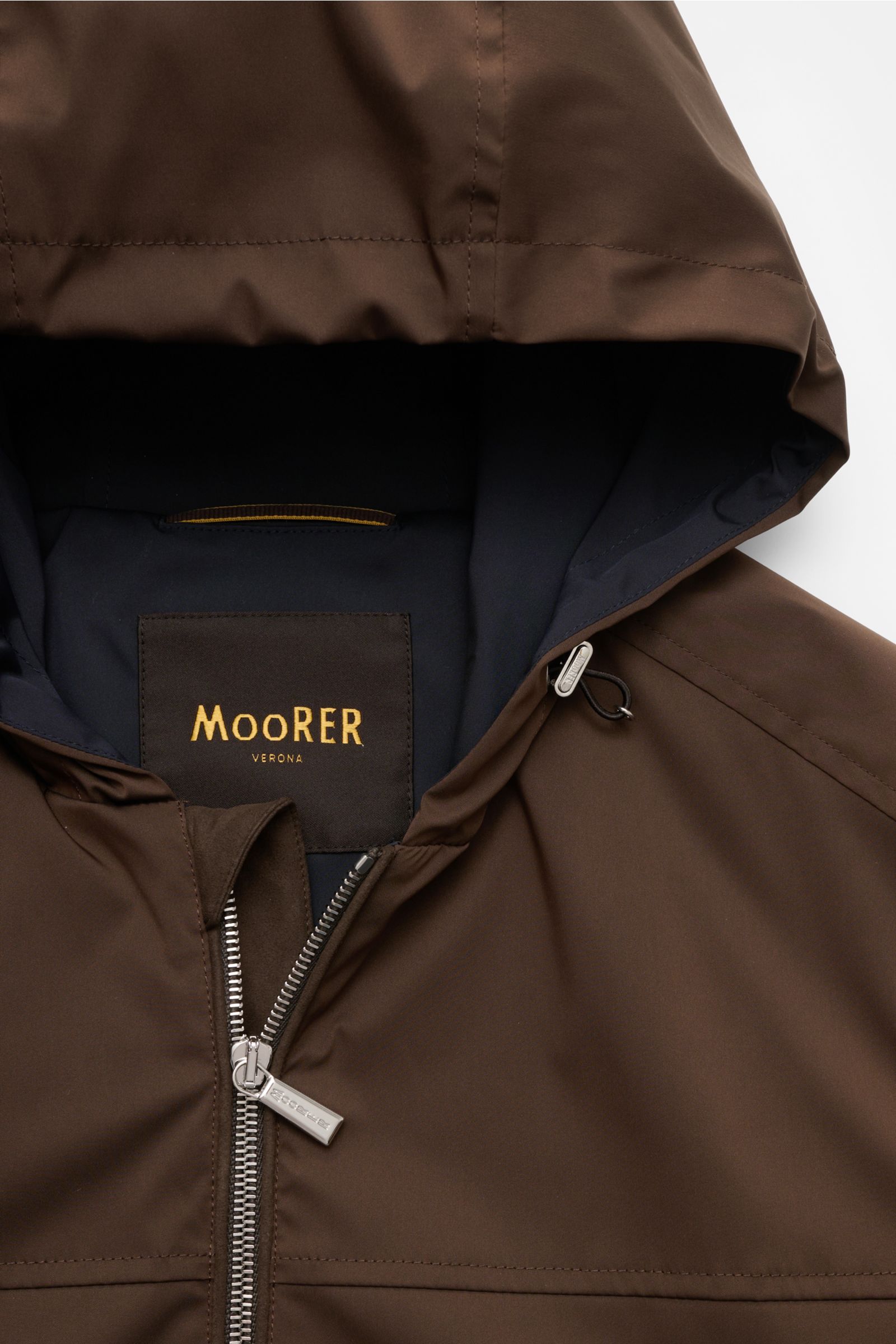Close-up front view of the Moorer Blouson 'Albori TJ' dunkelbraun showing the dark brown water-repellent microfiber fabric, smooth texture, silver zipper, and hood with drawstring. Outdoor-Essential mit Anspruch: Der Blouson von MOORER verbindet funkti