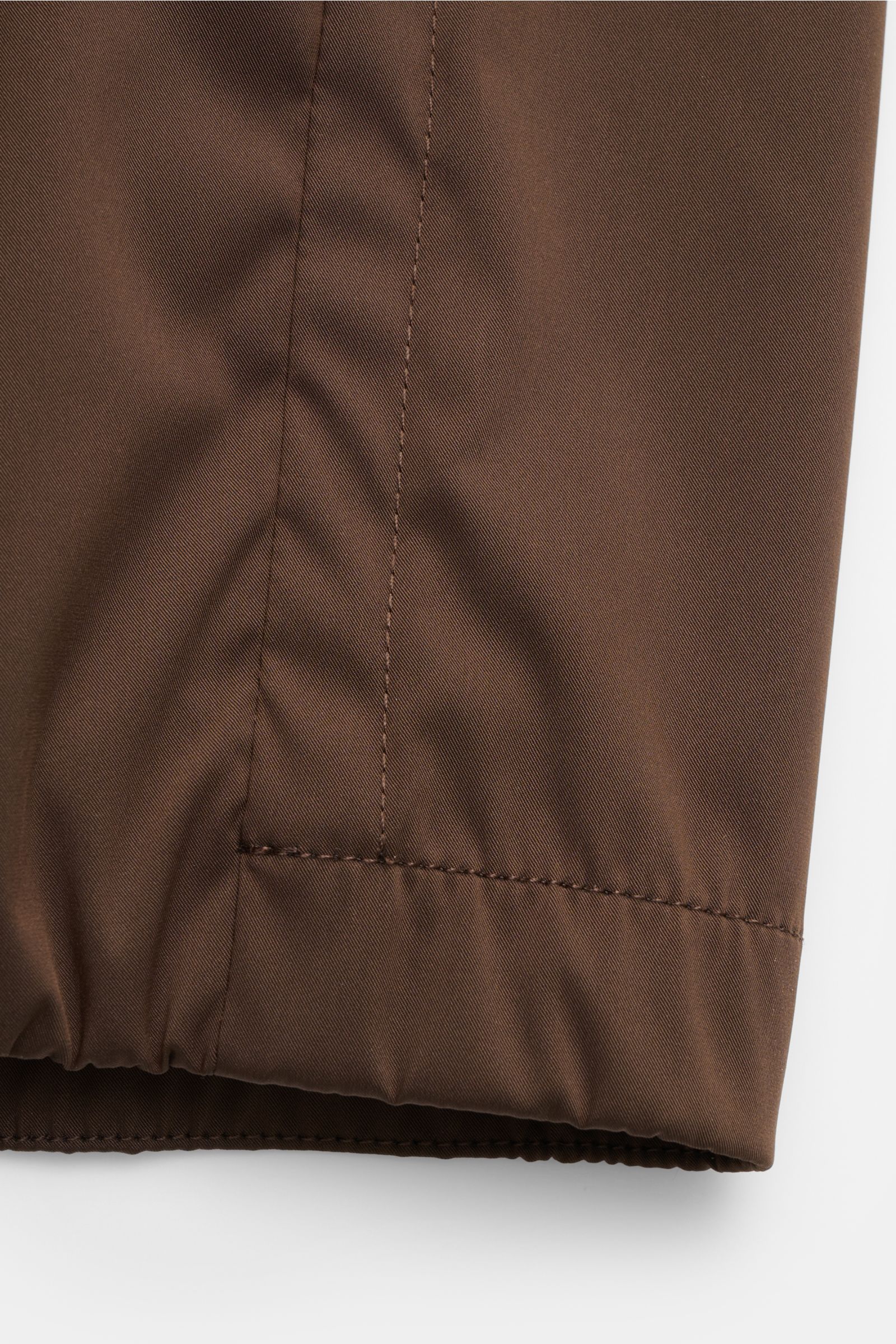 Close-up front view of the elastic hem and sleeve cuff of the Moorer Blouson 'Albori TJ' dunkelbraun, made of high-quality microfiber with a smooth touch, water-repellent, slim fit, featuring a hood with drawstring, zipper front pockets, elastic hem and c
