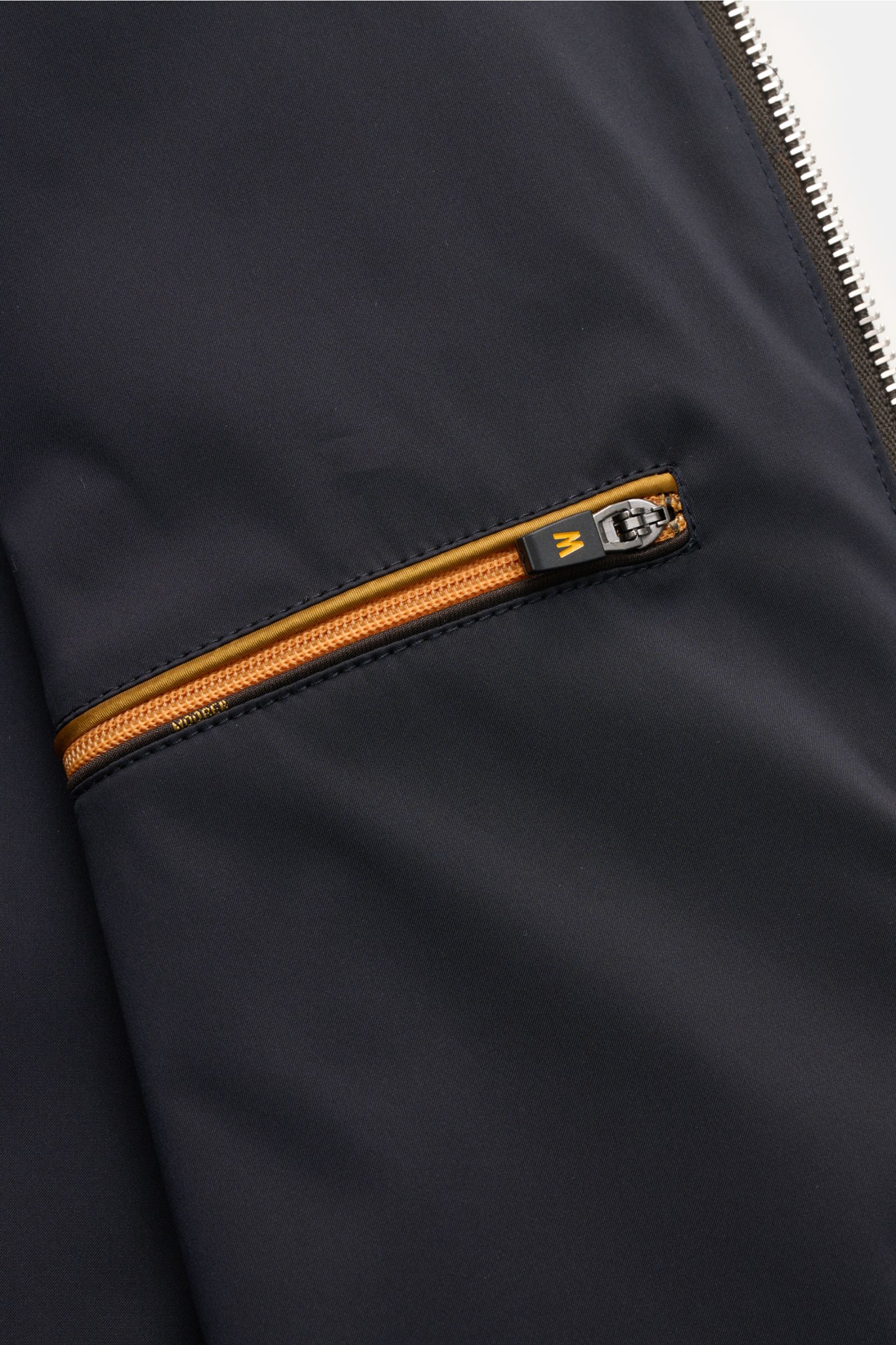 Close-up front side view of the zipper pocket on the Moorer Blouson 'Albori TJ' dunkelbraun, made from high-quality microfiber with a smooth touch, water-repellent finish, slim fit, hood with drawstring, elastic hem and cuffs, smooth lining, and two inner