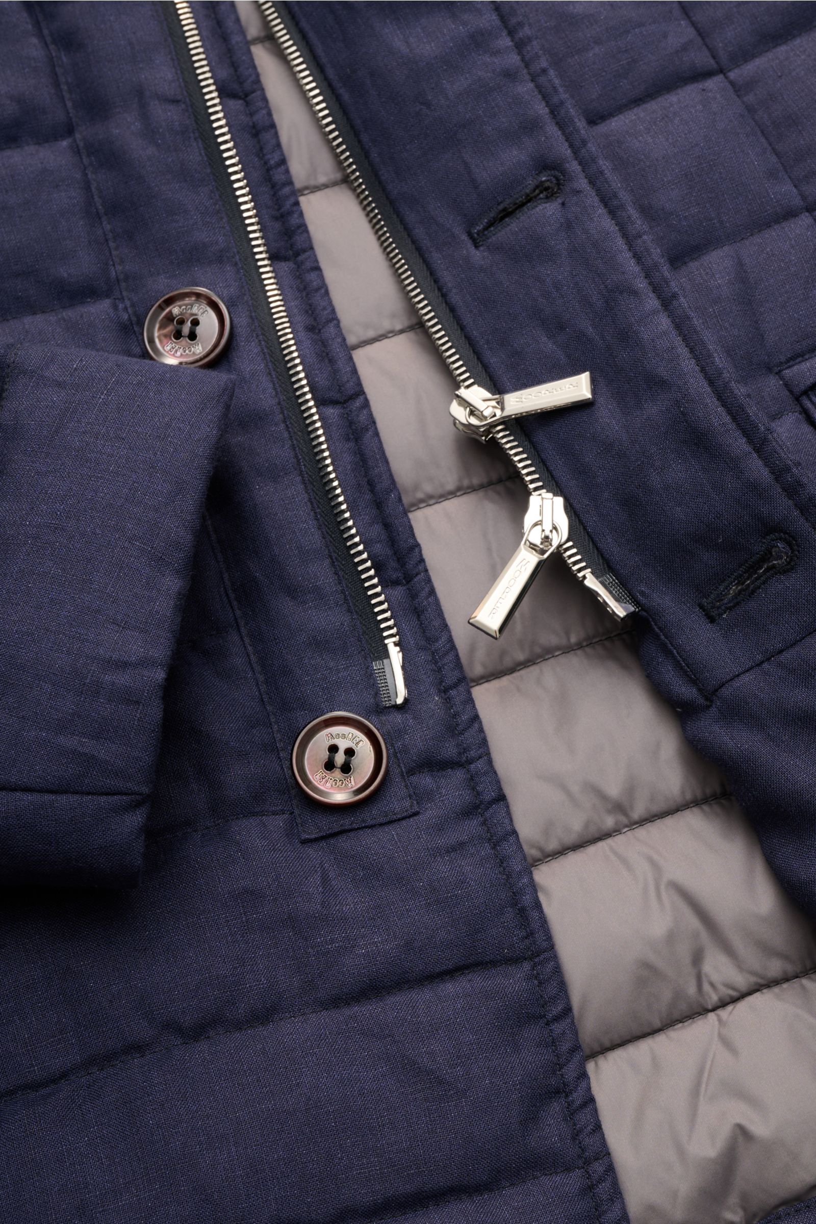 Close-up front view of the Moorer Down jacket 'Zavyer' navy mottled showing quilted pure linen fabric, two-way silver zipper, buttons, and smooth grey down lining. The elegant quilted jacket 'Zavyer' by MOORER will see you through the transitional season 