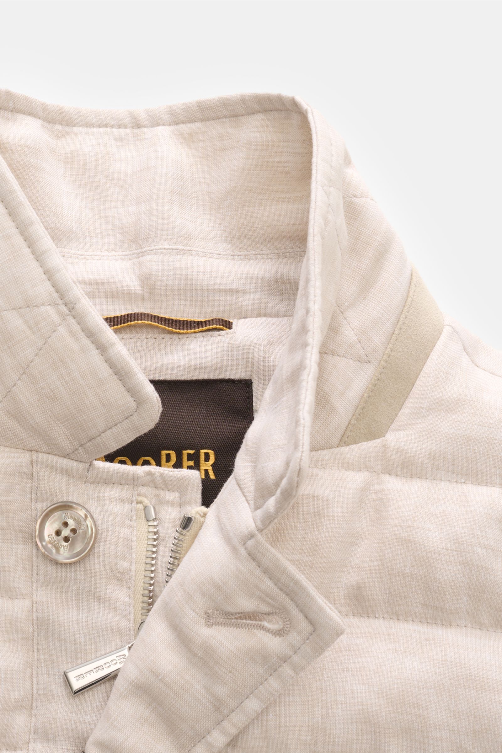 Close-up front view of the Moorer Down jacket 'Zavyer' beige mottled, showing the collar, button, zipper, and fabric texture. The elegant quilted jacket 'Zavyer' by MOORER is perfect for transitional seasons with pure linen, smooth feel, classic topstitch