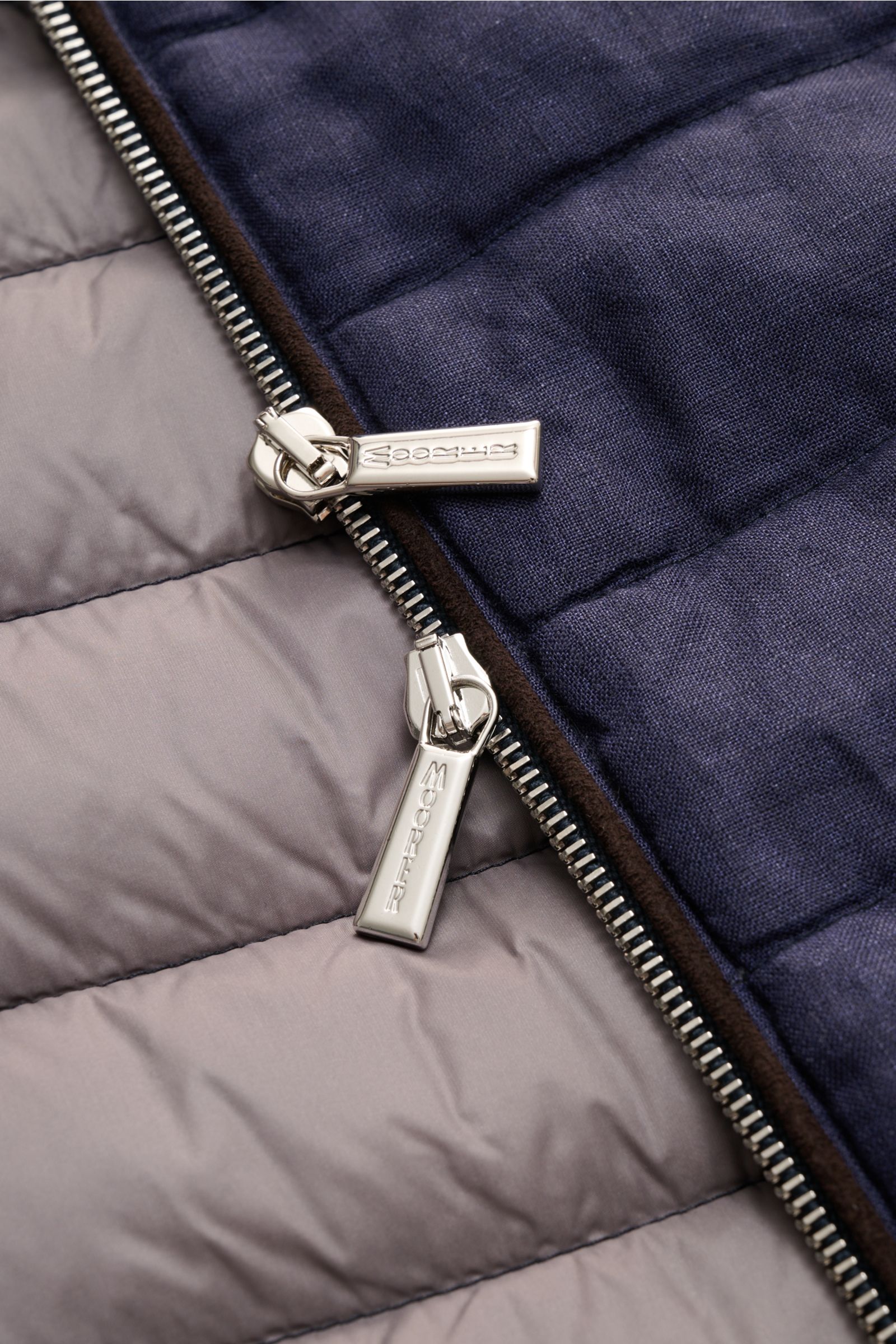 Nahaufnahme der Moorer Daunenjacke 'Alec' navy meliert, Detailansicht des Zwei-Wege-Reißverschlusses, reines Leinen, leichte Daunenfüllung, glattes Futter, Slim Fit, Kapuze im Kragen versteckt.