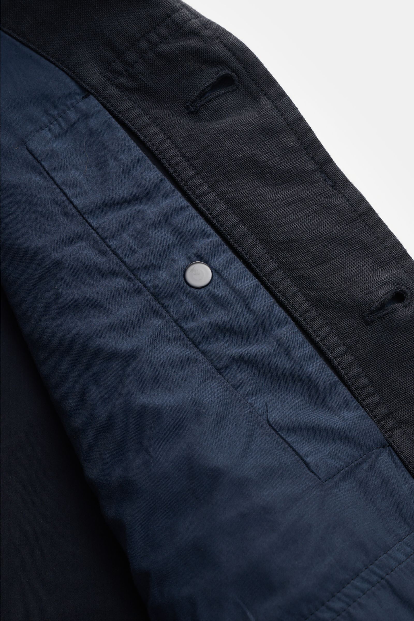 Close-up top view of the Stone Island Jacket 'Ghost Piece' navy showing the linen and microfiber blend fabric, concealed button placket, and snap button cuff details. Springtime meets casual: This STONE ISLAND jacket from the 'Ghost' Capsule has been made