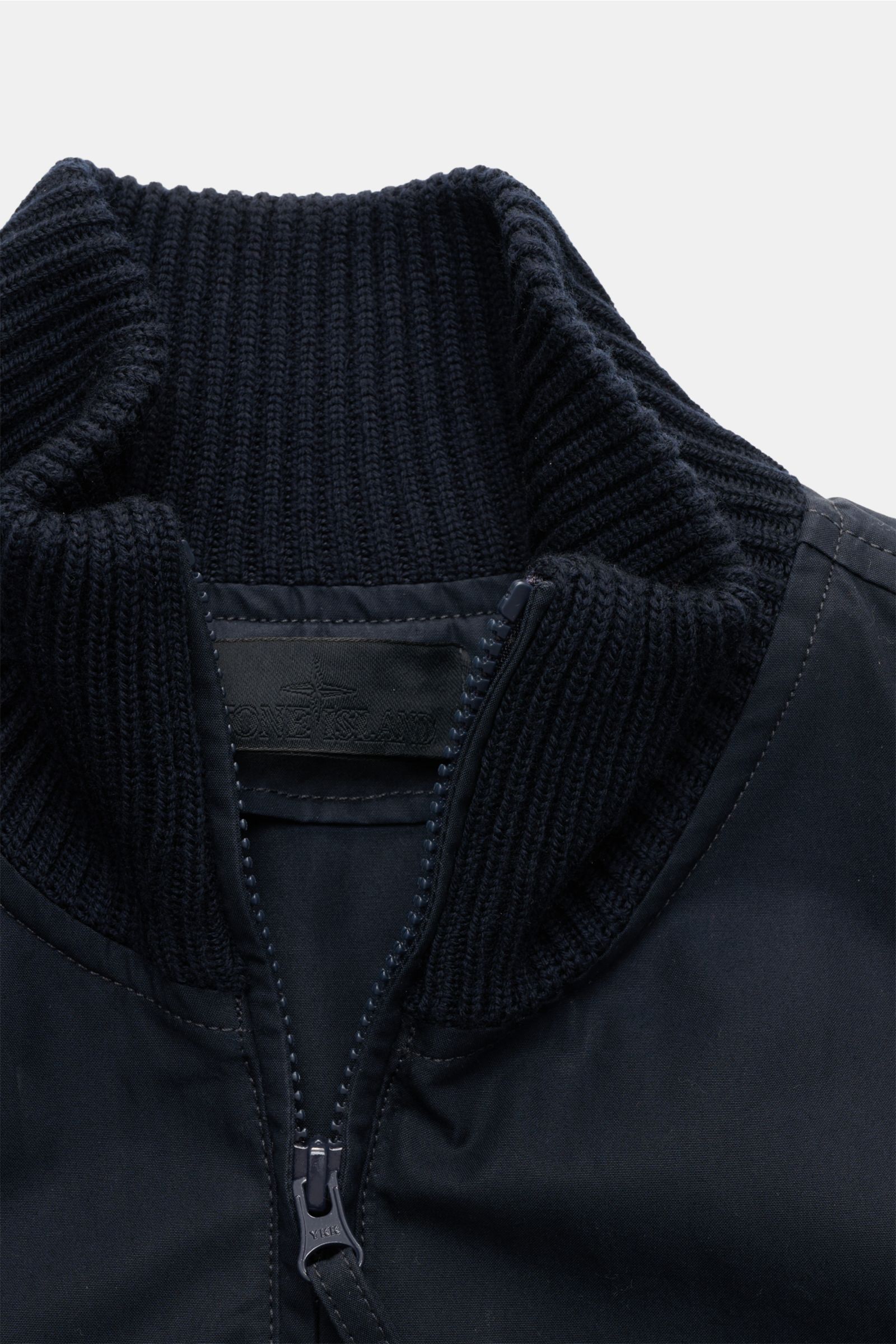 Stone Island Blouson 'Ghost Piece' navy, Detailansicht des hoch schließenden Strickkragens mit weichem Griff und zwei-Wege-Reißverschluss, Slim Fit, Baumwolle und Wolle, tonales Badge am Oberarm sichtbar.