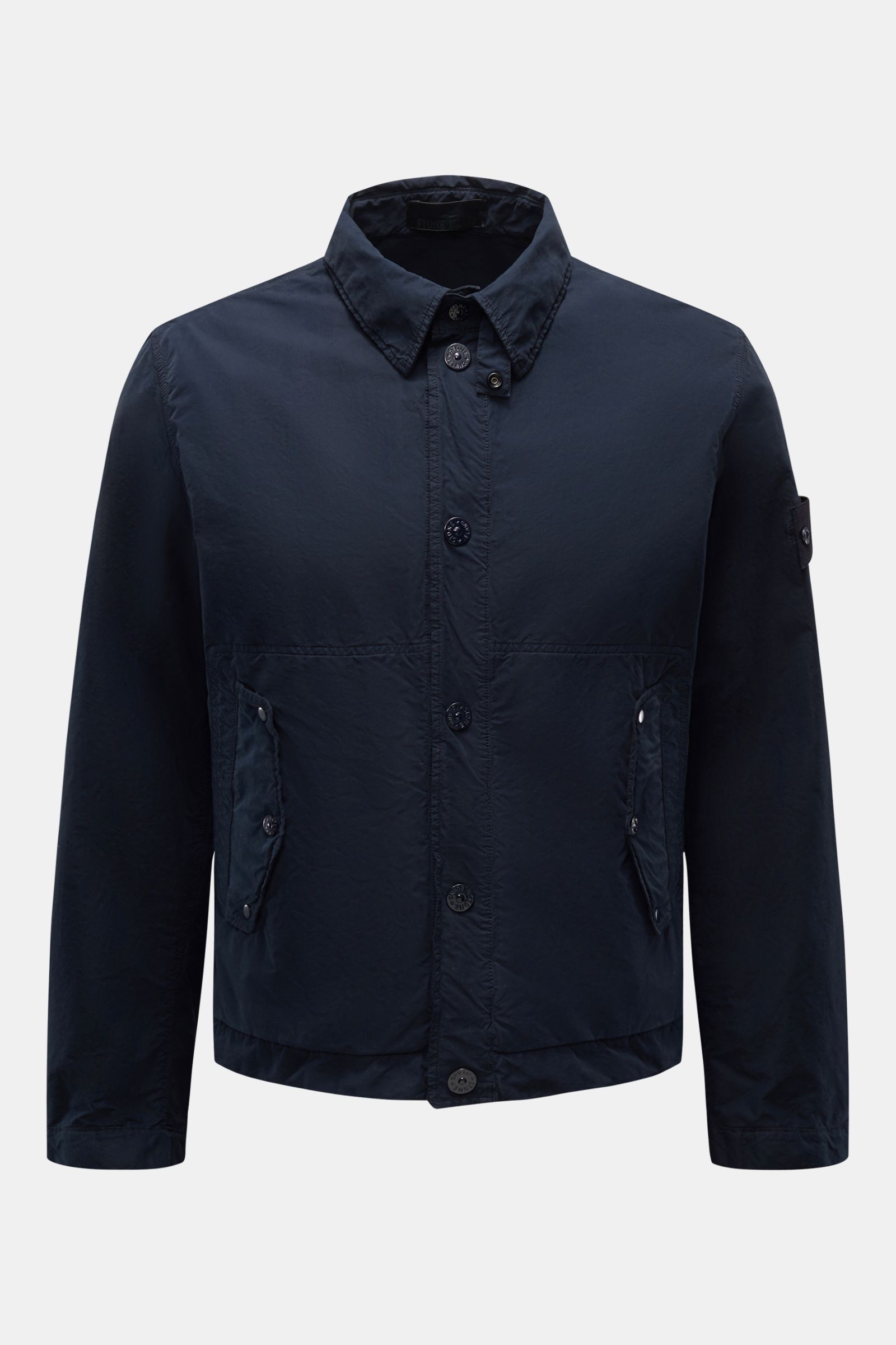 Front view of Stone Island Jacke 'Ghost Piece' navy, an urban essential jacket with slim fit, garment dyed microfiber, snap button placket, turn-down collar with button tab, flap front pockets, tonal compass badge on upper arm, and snap button cuffs.