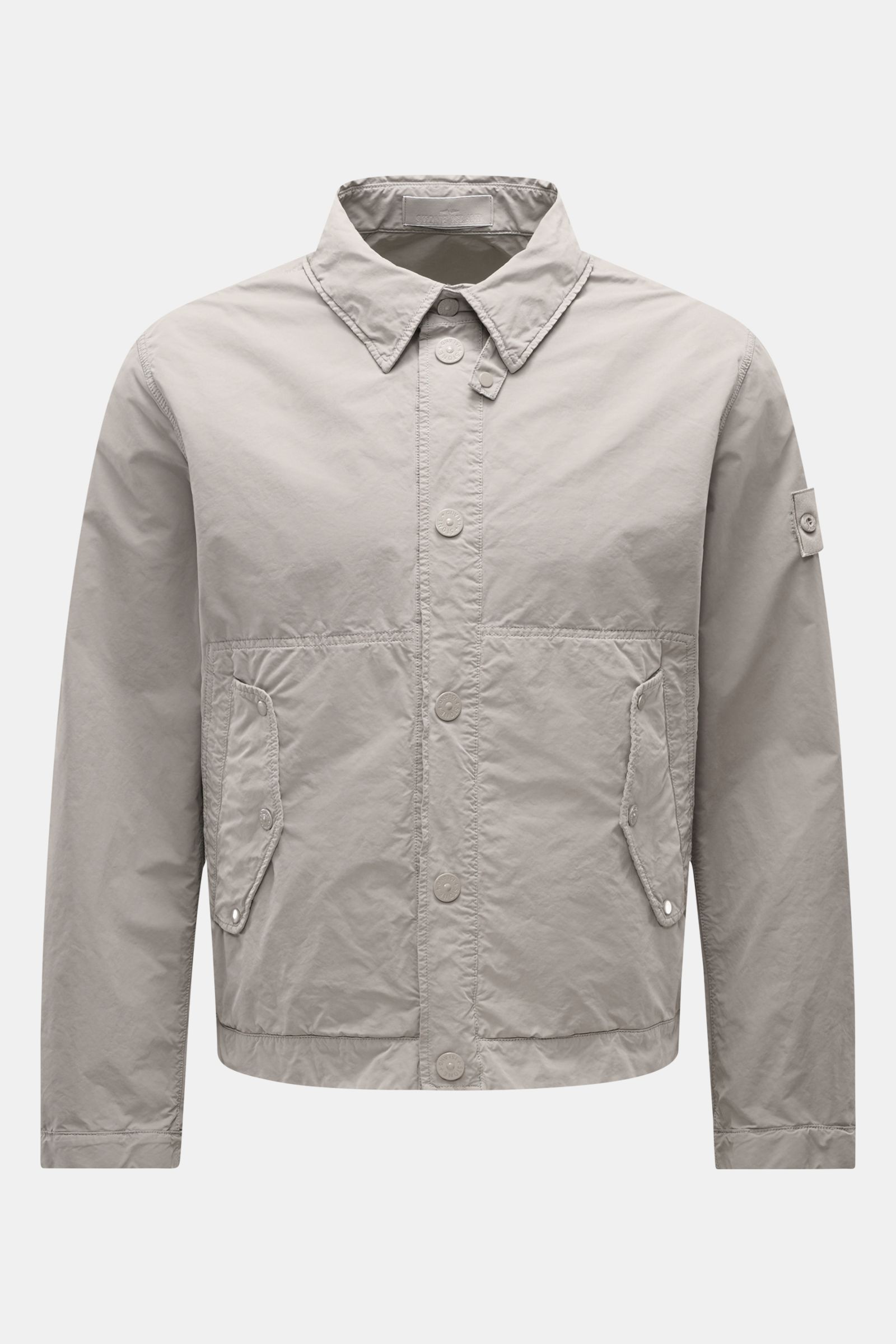 Front view of Stone Island Jacket 'Ghost Piece' light grey, slim fit with snap button placket, turn-down collar, flap pockets, and tonal compass badge, made of high-quality microfibre with a soft feel. Urban essential for any occasion.